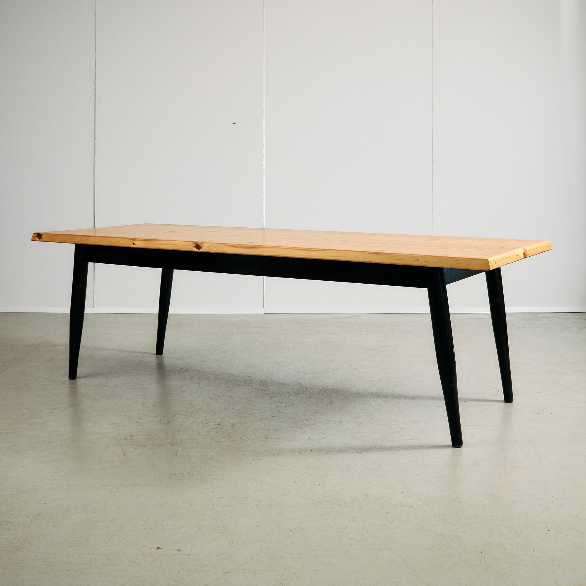 Fabriquée en pin canadien massif, cette longue table apporte une force tranquille et une chaleur naturelle à tout espace. Le plateau de table imposant met en valeur le grain organique du bois, tandis que les pieds laqués noirs offrent un contraste
