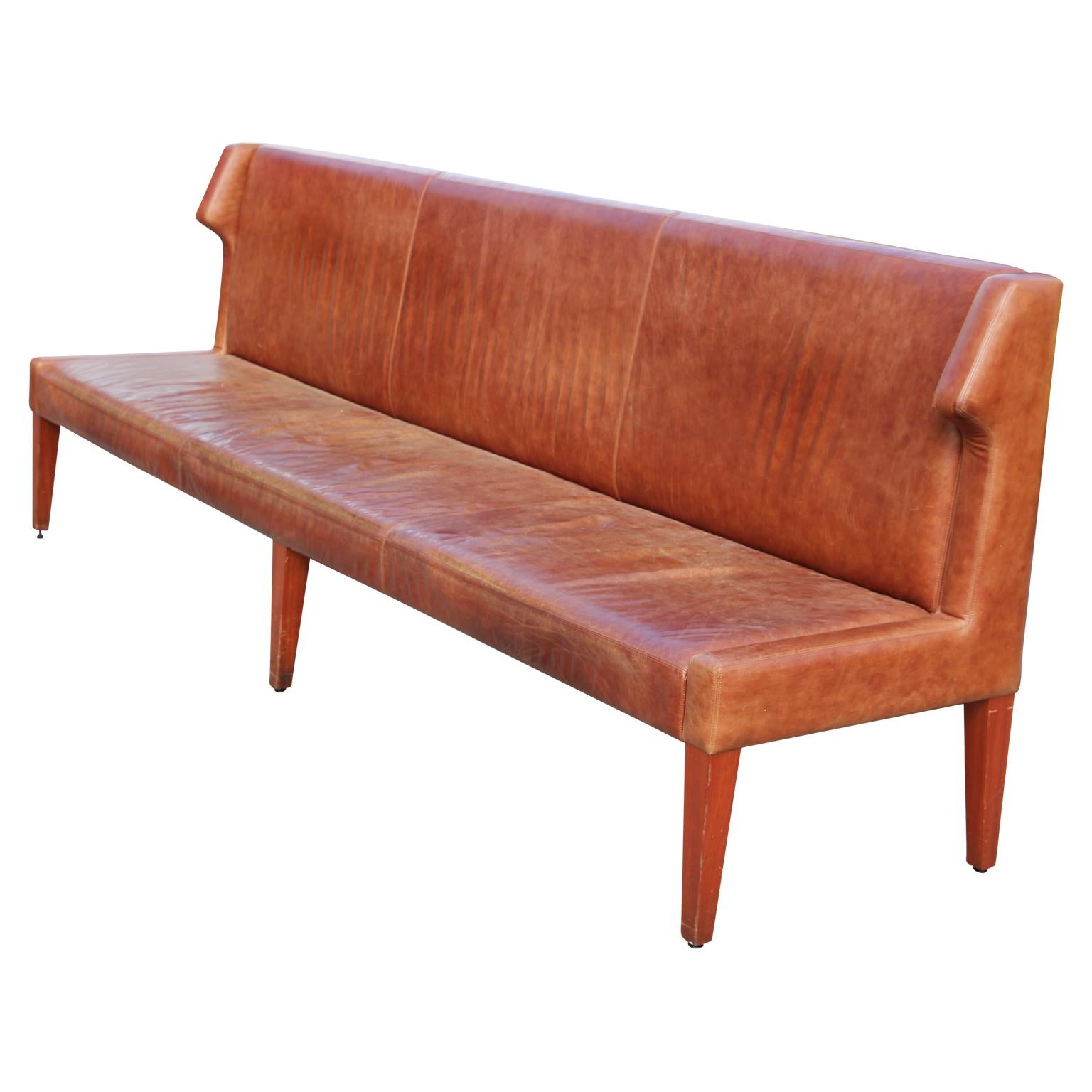 Long leather sofa designed by Jordan Mozer for the notable Américas Restaurant, Houston, TX (2012). Each sofa is upholstered in beautiful tan distressed leather. No rips or tears but has lots of wear. 

Jordan Mozer is the founder and principal of