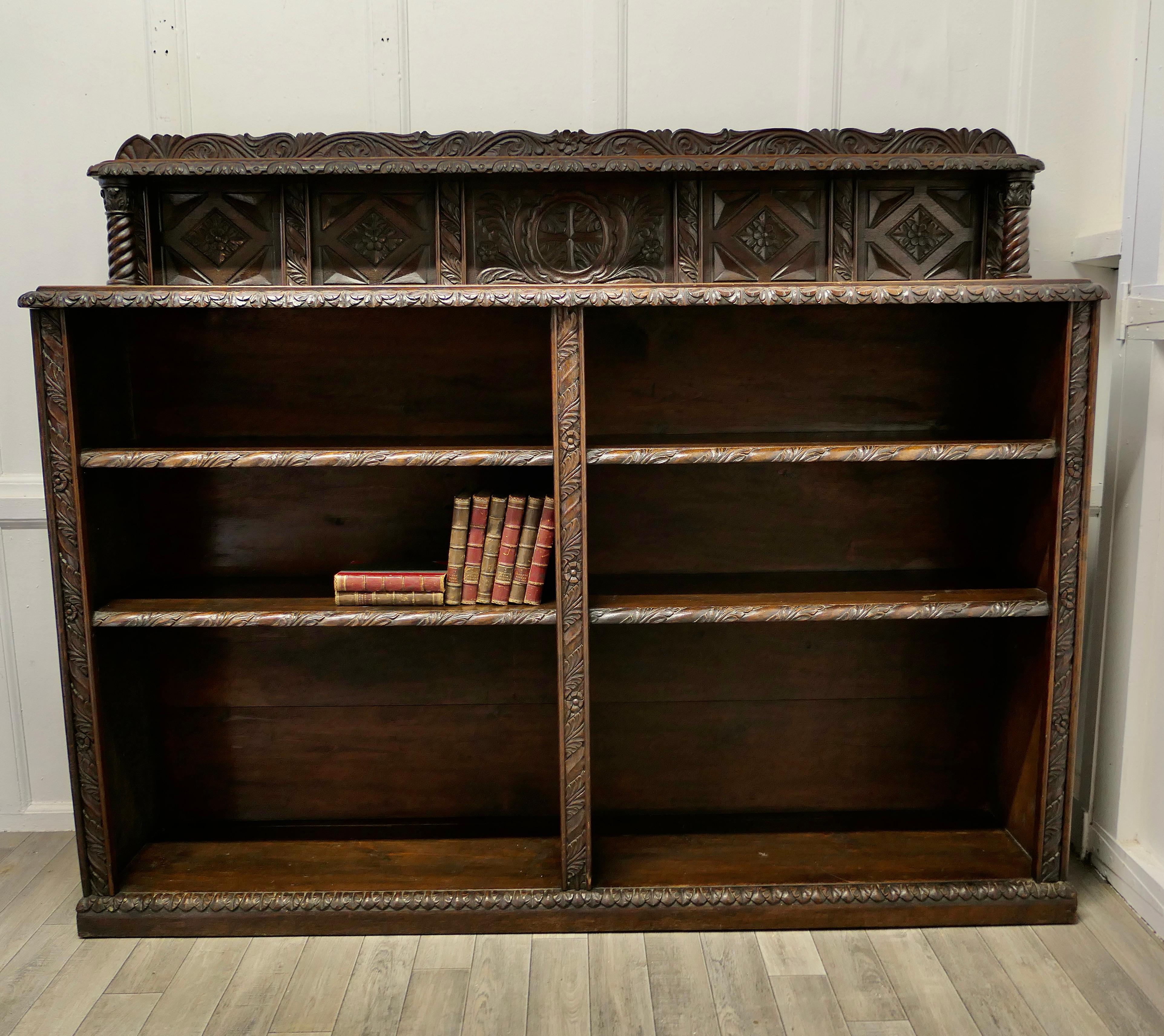 Long carved Arts and Crafts Gothic oak open book case

The book case is in carved oak, it is double length with a small carved shelved galleried back.
Both sides of the bookcase have 3 storage sections, the top shelf is 9” high, the next is 10”