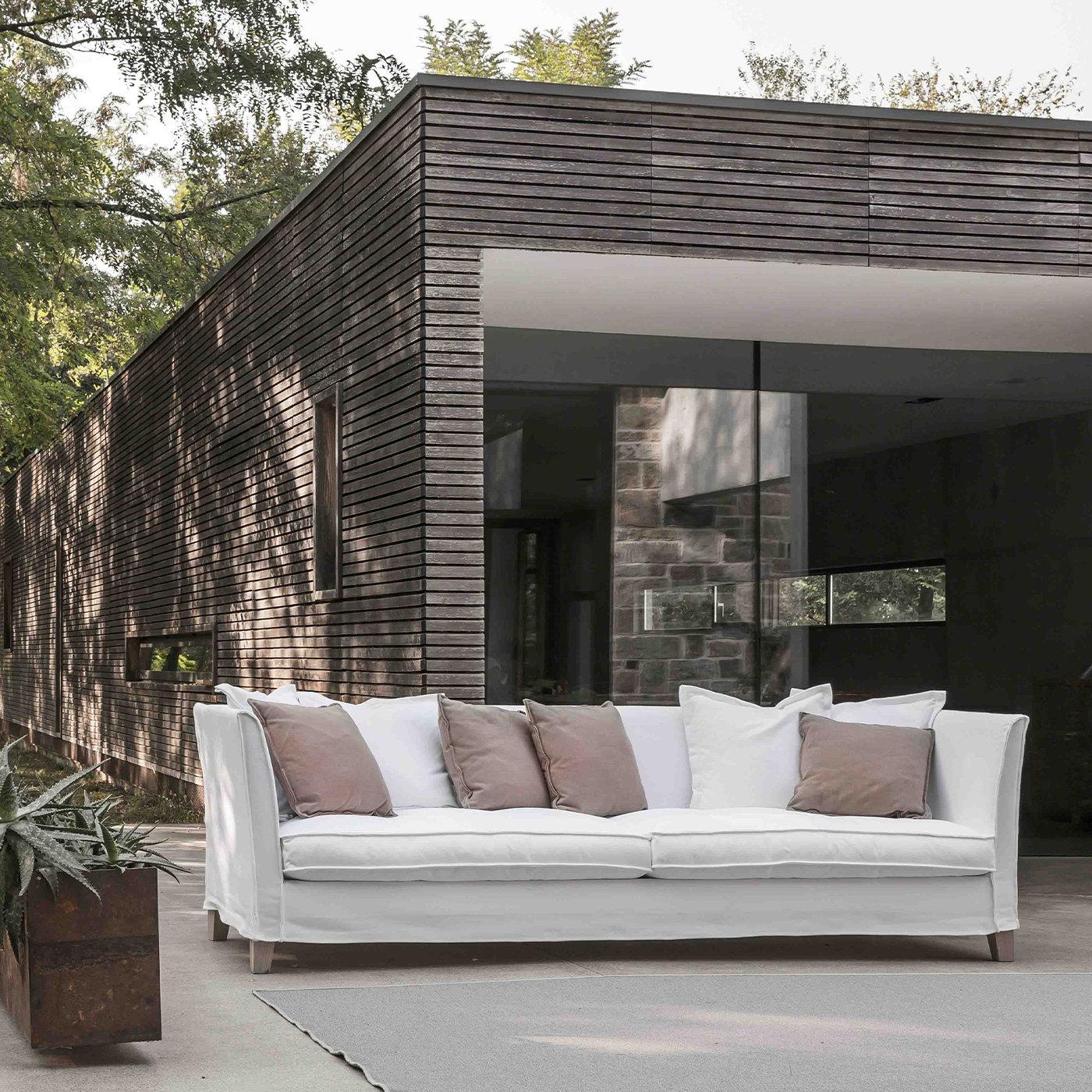 This clean-lined sofa raised on varnished wooden feet will elevate an outdoor lounge with its simple elegance. Polyurethane padding with waterproof lining pads the solid wooden structure, upholstered with white fabric (removable) marked by
