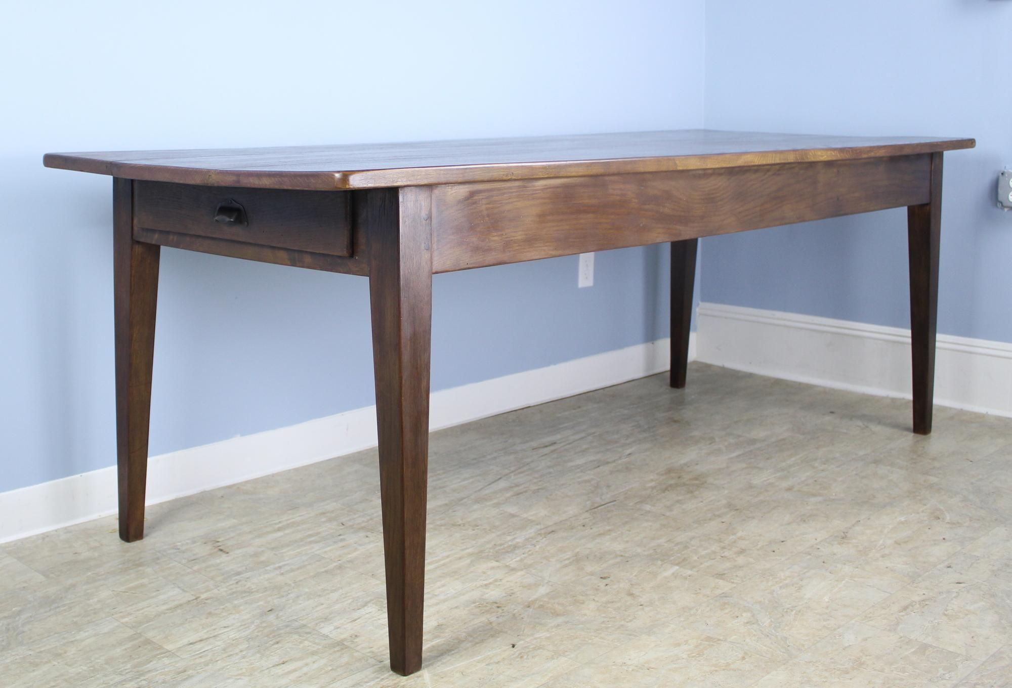 A generously proportioned chestnut farm table, custom made for Briggs House in France. This long table is almost 35 inches deep, providing excellent space for dining. It is very good looking, with dark rich color and dramatic chestnut grain. There