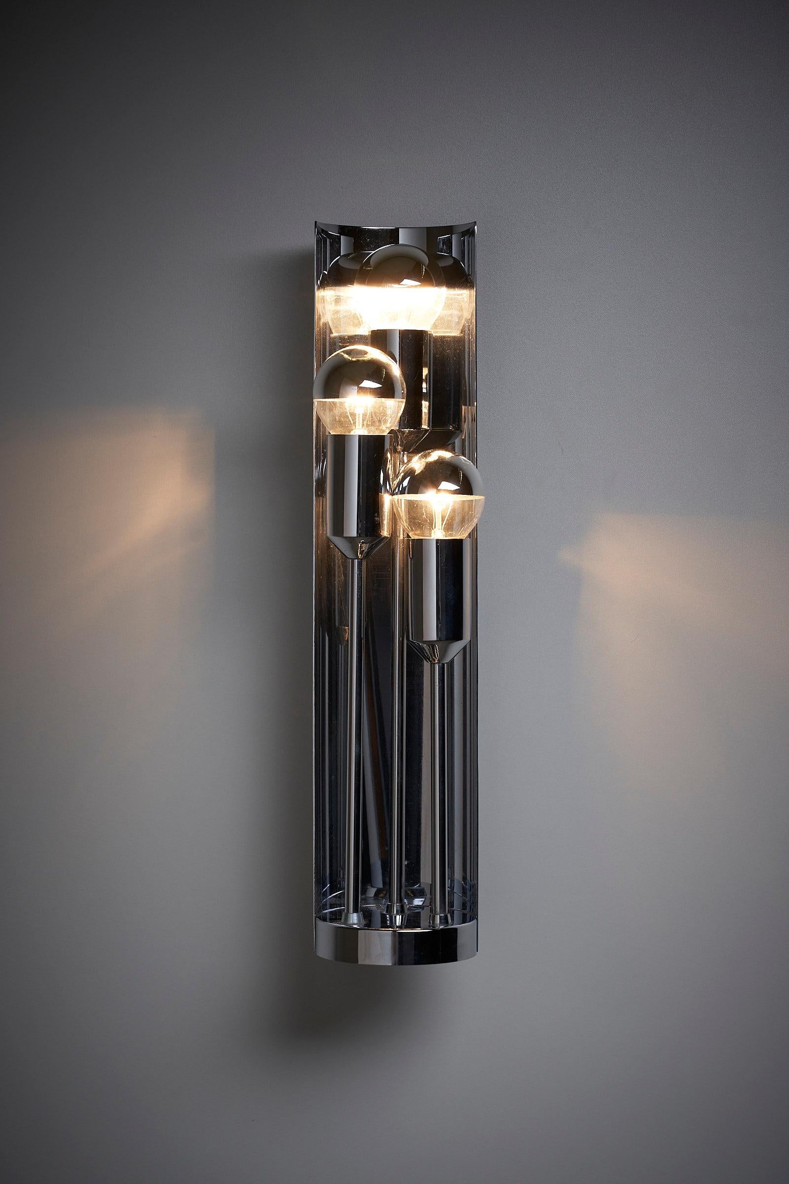 Introducing the Space Age Wall Lamp with Reflector, a remarkable creation by Cosack that exudes futuristic charm. This fully chrome lamp features sleek lines and a captivating design that is sure to make a statement in any space.

The focal point of