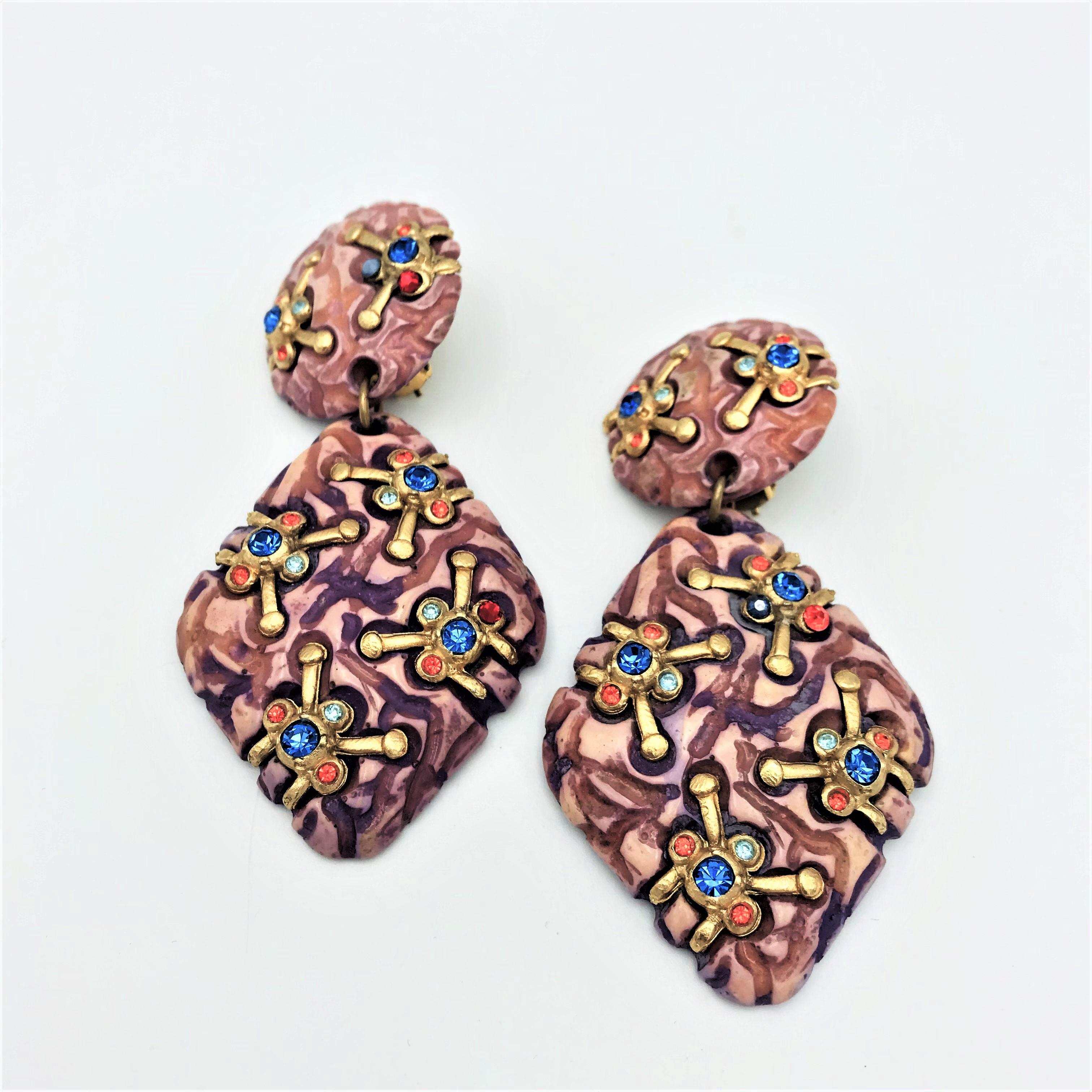 About 
Long 2-part ear clips by Jacky de G from France made of resin and decorated with colorful rhinestones. Made from resin in the 1980s France.
Measurement
Full length 9 cm, the round part 3 cm in diameter, the attached part is 5.5 x 4.3 cm