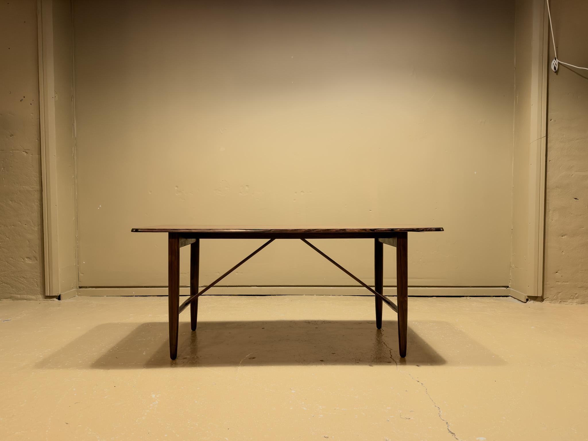 Dieser dänische Couchtisch aus der Mitte des Jahrhunderts ist ein atemberaubendes Beispiel für die Handwerkskunst der Mitte des Jahrhunderts. Er zeichnet sich durch ein schlichtes, minimalistisches Design aus, das die Schönheit des reich gemaserten