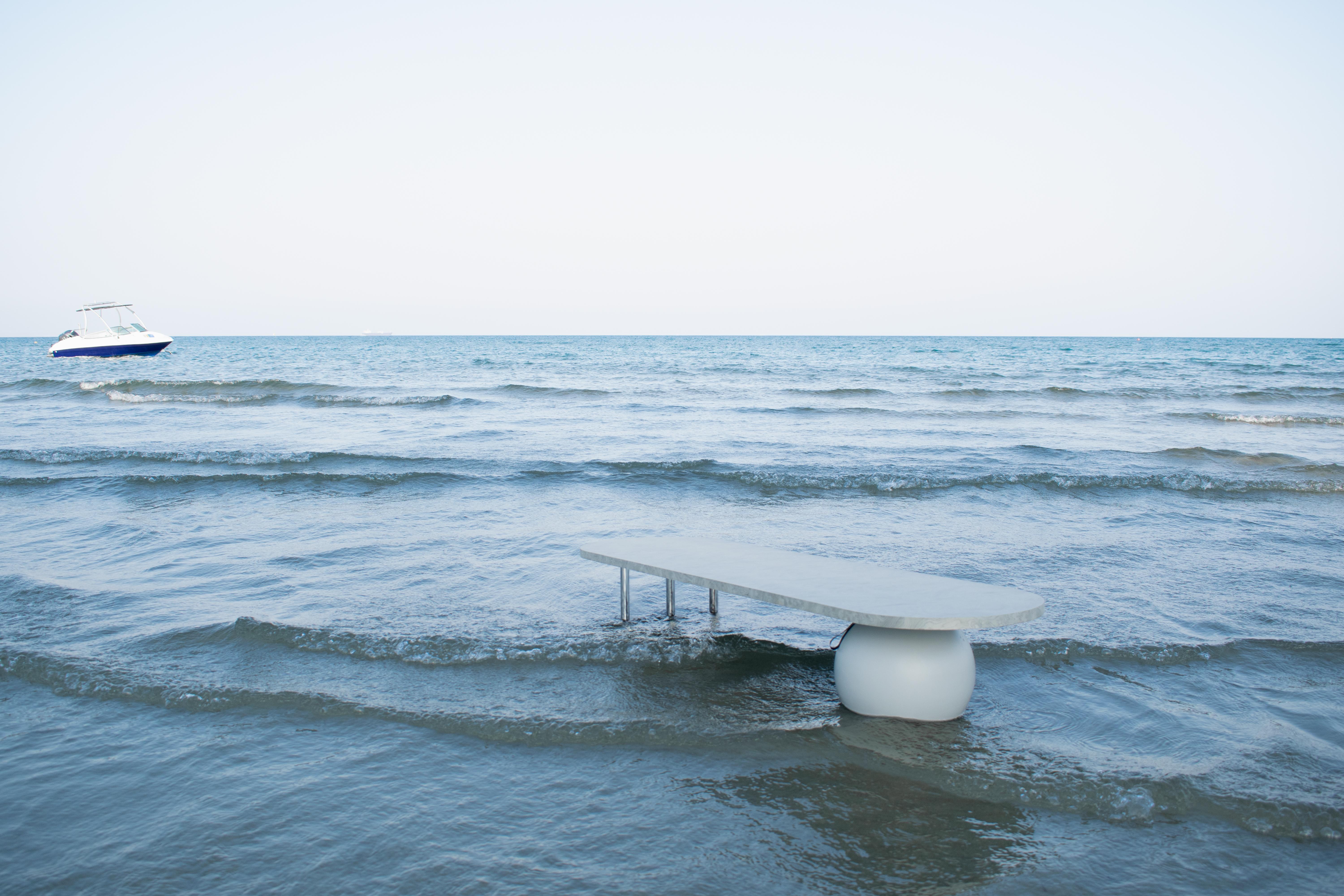 Wooden bulb veneer in silver color, stainless steel stiles and a Swedish pine solid wood sphere lacquered in grey color.

The SEA SURFACE long coffee table evolved out of its fellow designs of the high and low sea surface tables. Supported by