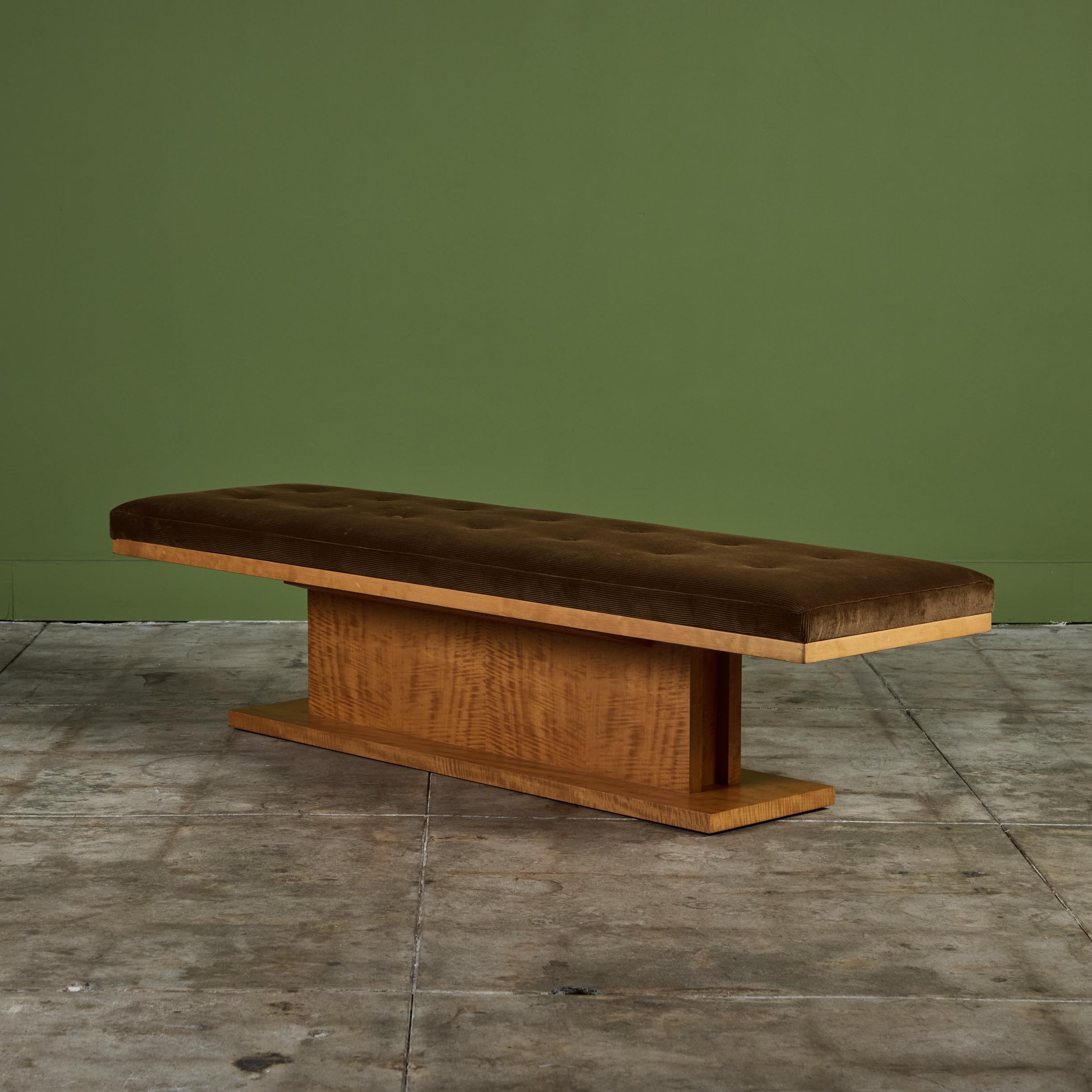 Long bench with cherry wood pedestal base. This example has been newly upholstered in a brown corduroy fabric with tufting throughout the seat, supported by a solid rectangular base.

Dimensions
67