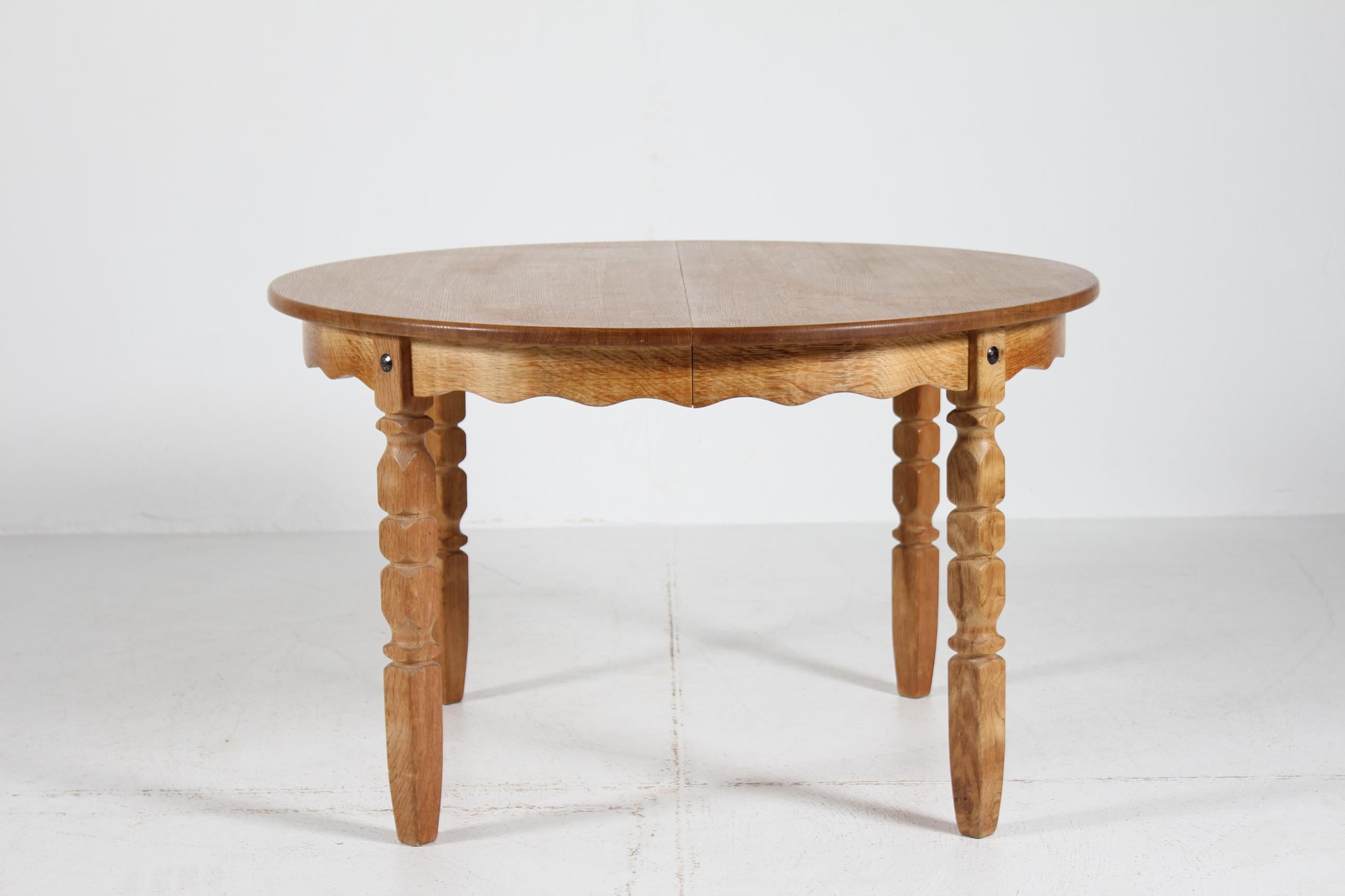 Grande tavolo da pranzo danese vintage Henning Kjærnulf rotondo a 2 foglie allungabile con gambe intagliate.
Prodotto in Danimarca negli anni '70.

Il tavolo è realizzato in rovere massiccio (impiallacciatura in rovere sull'anta).
Can può essere