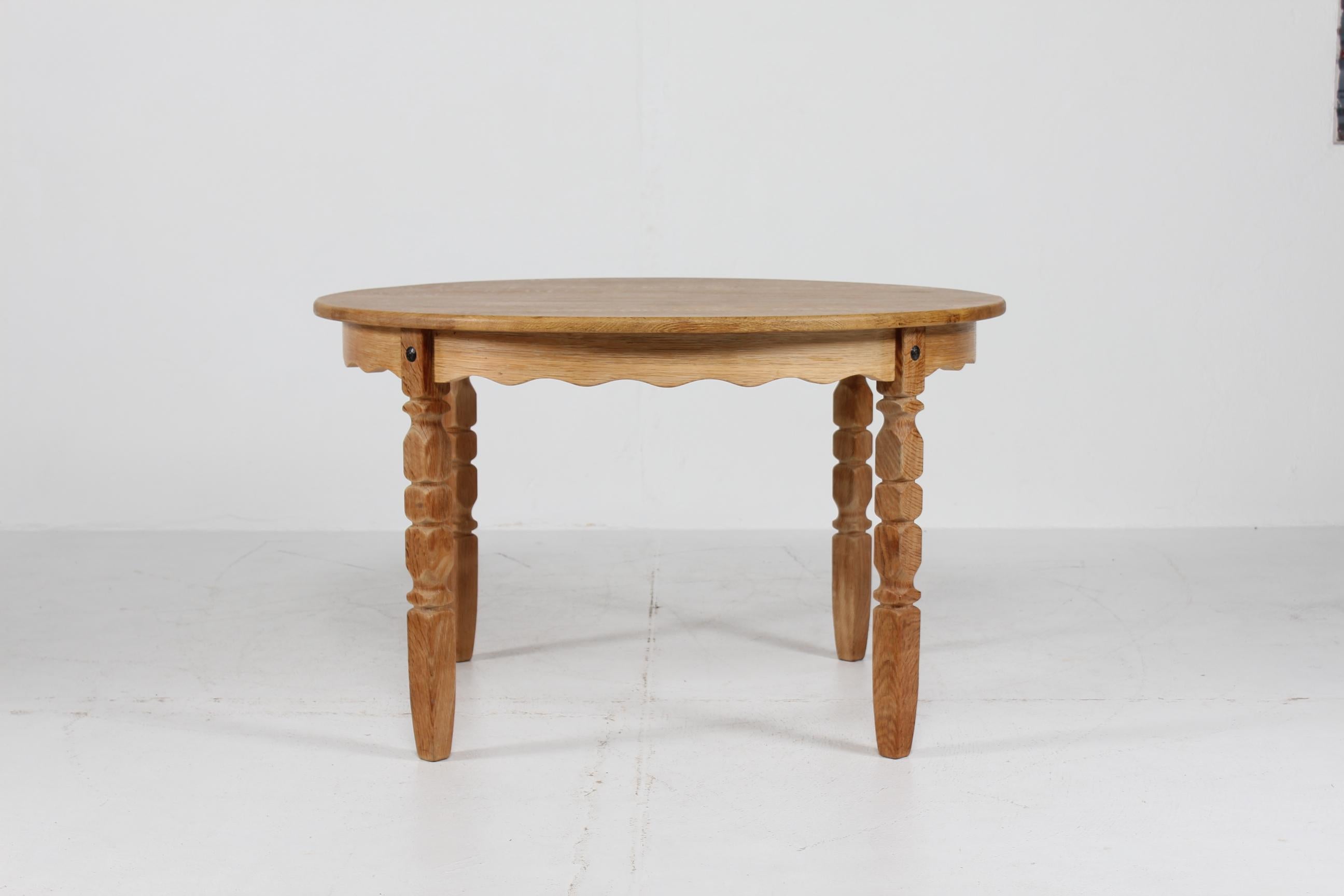 Large Danish vintage Henning Kjærnulf round 3 leaves extendable dining table with carved legs.
Manufactured in Denmark in the 1970s.

The table is made of solid oak (oak veneer on the leaves).
It can be extended with three extra leaves. One of the