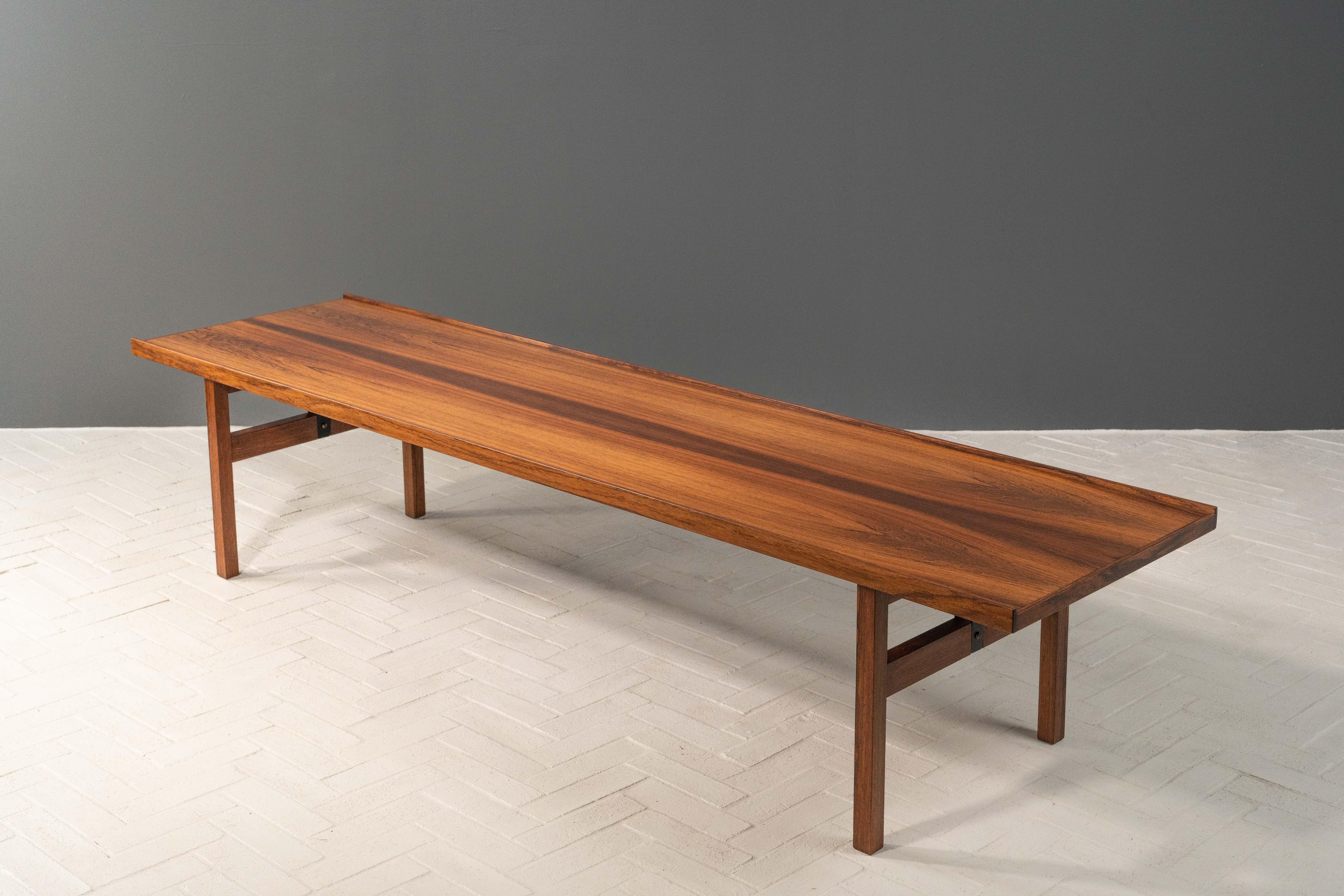 Danemark, vers 1960. Un long banc ou une table basse de style Krobo, probablement du designer norvégien Torbjørn Afdal. Fabriqué en bois de rose, il est doté d'un généreux plateau rectangulaire orné d'une lèvre subtile. Les supports de pieds en