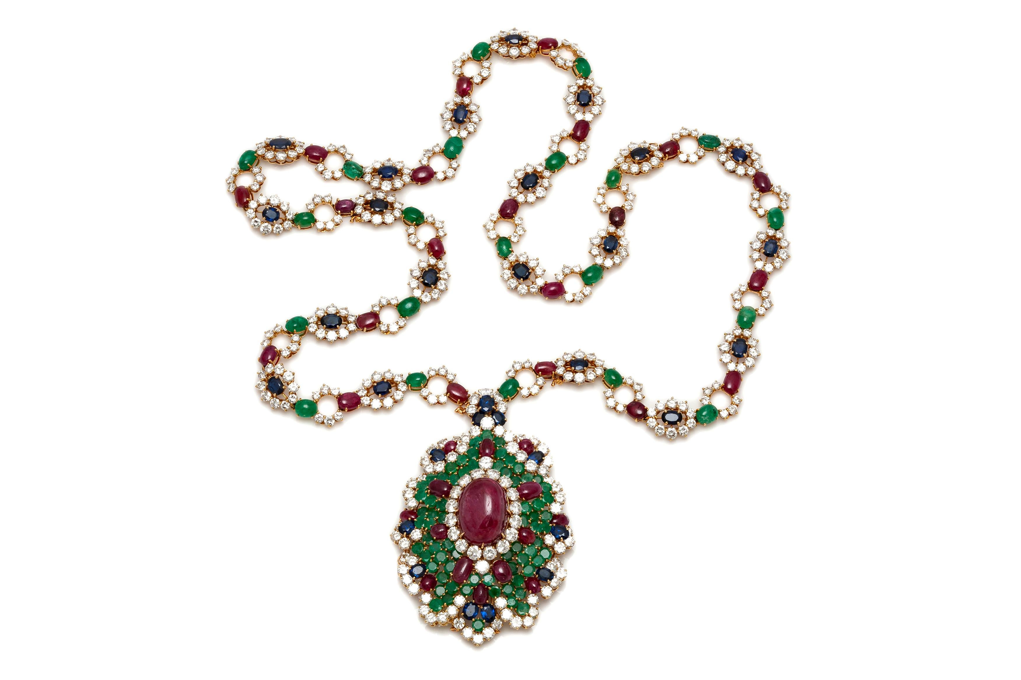 Finley crafted in 18k yellow gold with a center Cabochon Ruby weighing approximately 28.00 carats, additional 35 Cabochon Rubies weighing approximately a total of 31.50 carats, 21 Cabochon and 68 Round cut Emeralds weighing approximately a total of