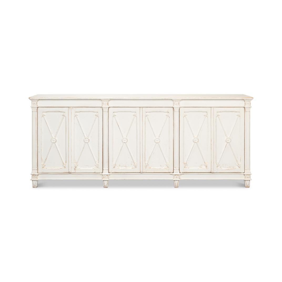 This piece features a hand-rubbed and distressed whitewash-painted finish, complementing its six doors adorned with a classic cross-arrow design. Crafted from high-quality pine, this buffet offers a rustic, antiqued finish that exudes old-world