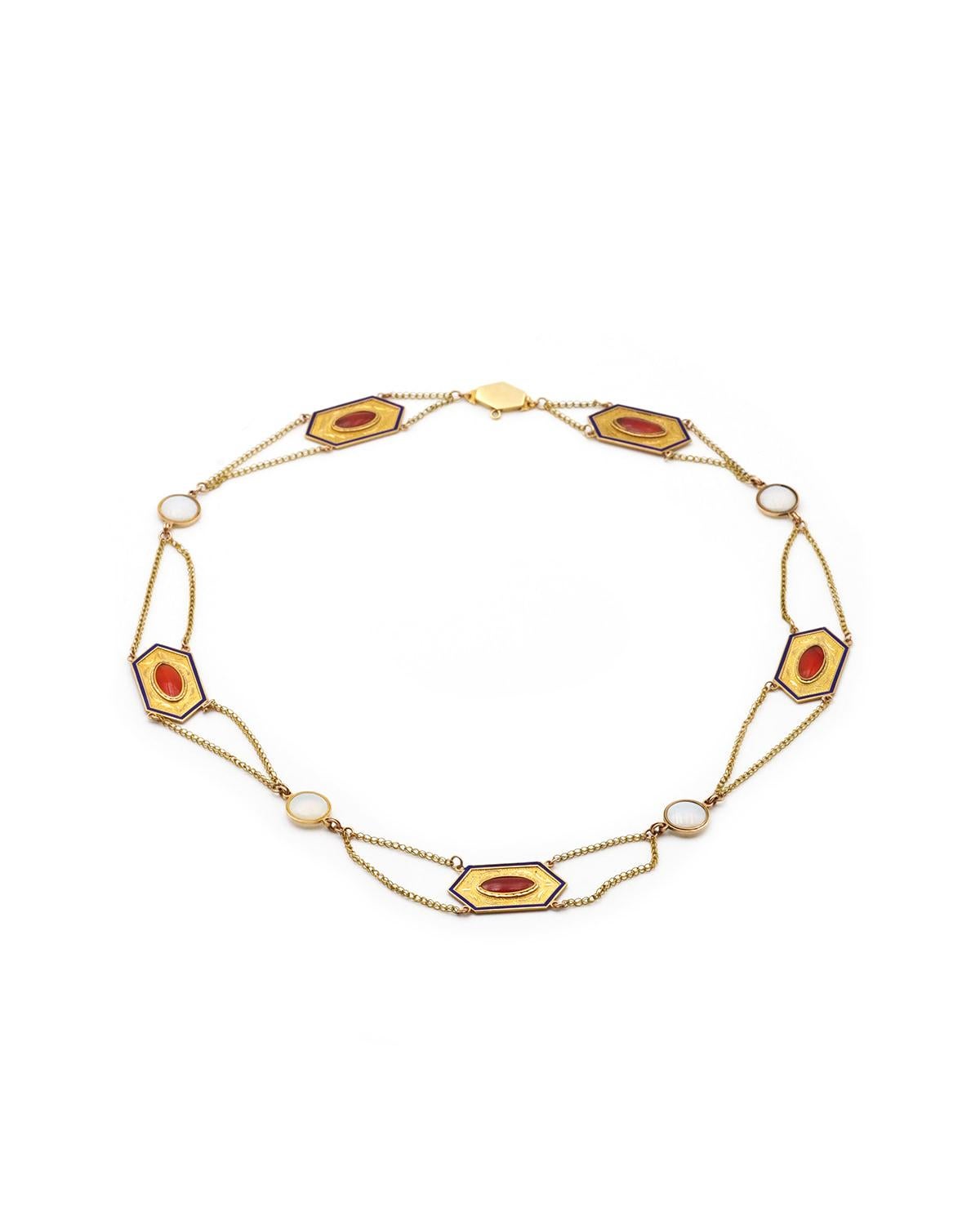 Collana Drapery First French Empire in oro giallo 18 carati. Questa collana è ornata da cinque placche esagonali cesellate e smaltate in blu notte, centrate da cabochon di corniola. Si alternano a cabochon di vetro opalescente bianco latte. Ogni