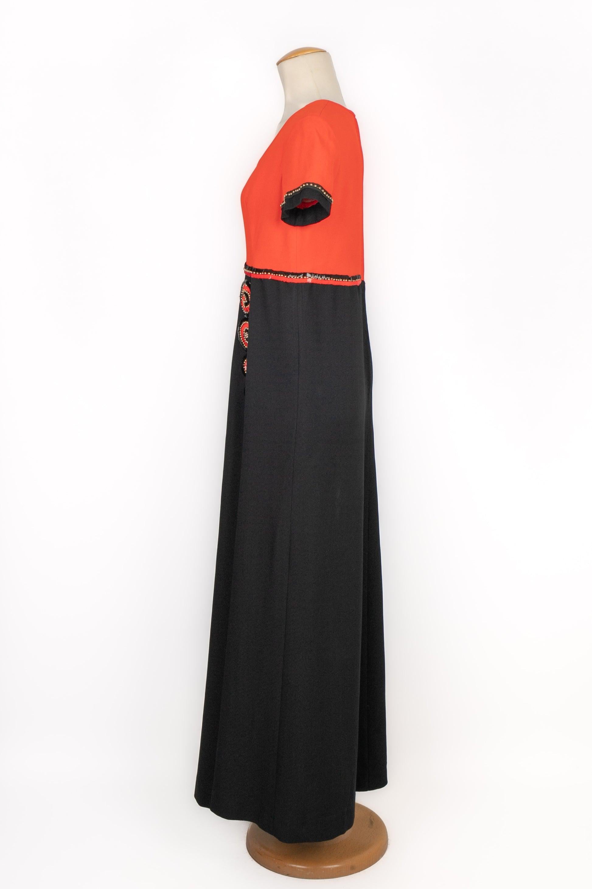 Vestido largo de manga corta naranja y negro cosido con lentejuelas. Faltan las etiquetas de talla y composición, se ajusta a una 38FR.

Más información:
Estado: Muy buen estado
Dimensiones: Anchura de los hombros: 39 cm - Pecho: 41 cm - Cintura: 37