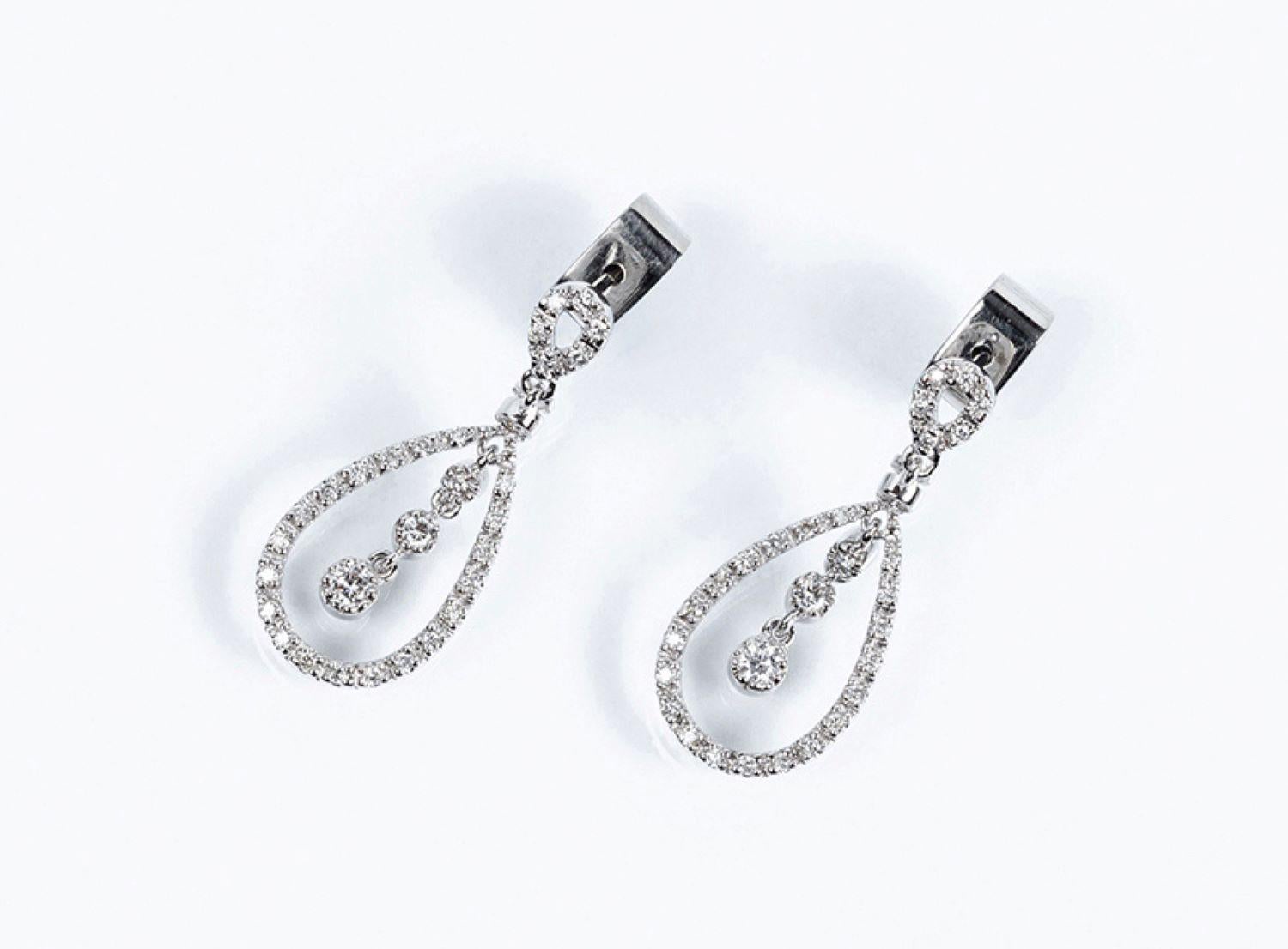 Pendientes largos de oro blanco y diamantes blancos limpios, talla brillante, en perilla calada con colgantes brillantes en el interior, todo en movimiento 
 8 bts: 0,20 ct y 58 bts: 0,40 ct  aproximadamente
 Características: Color H, pureza VS 

