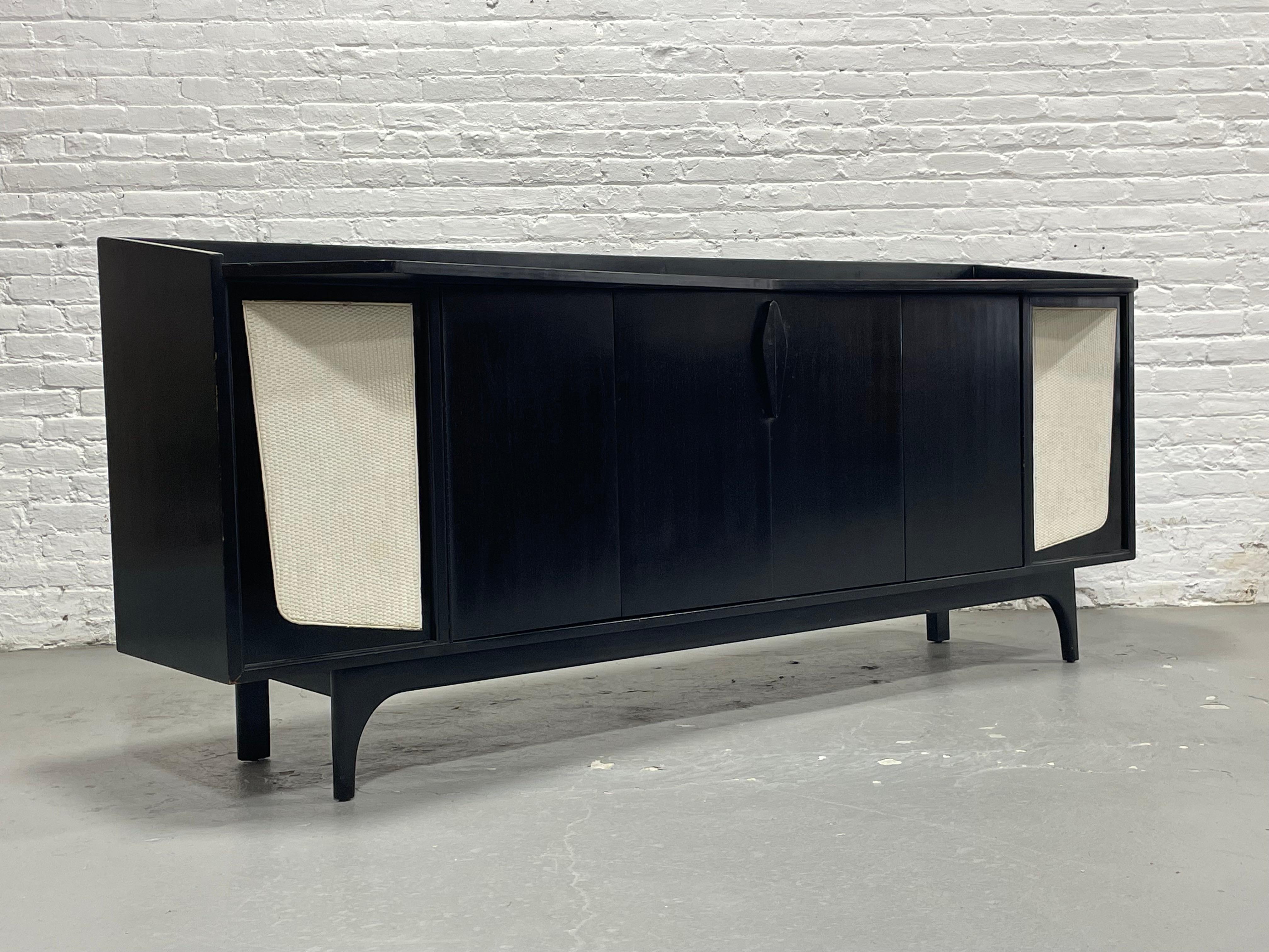 Armario estéreo moderno de mediados de siglo, extra largo, fabricado a medida en la década de 1960 y siguiendo el estilo de los icónicos diseños de Gio Ponti. Acabado en una elegante madera ebonizada mate, este aparador vintage está flanqueado por