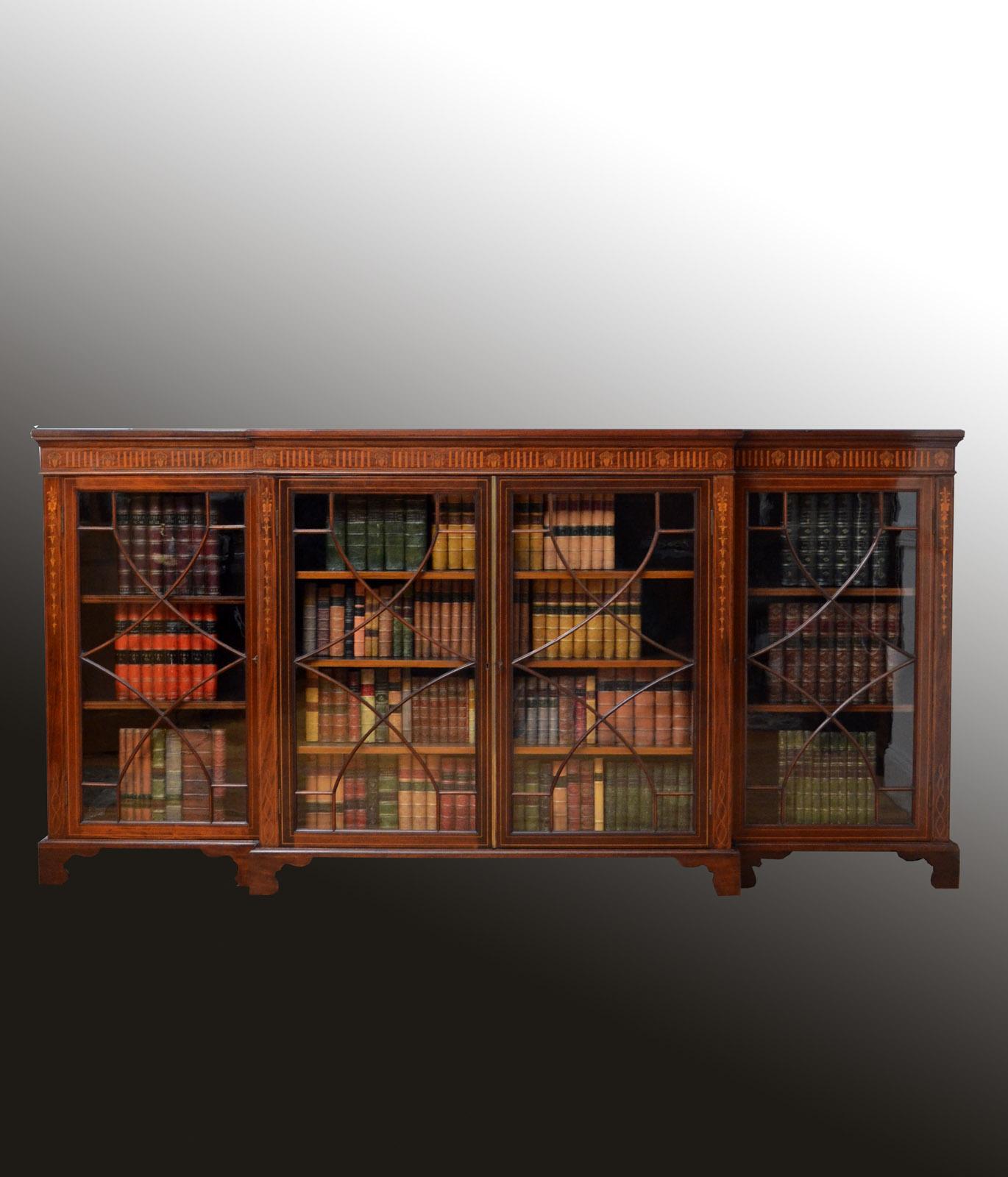 Sn4638, fine quality and very unusual, Edwardian low glazed bookcase in mahogany, having figured mahogany top with satinwood banded edge above finely inlaid frieze and a pair of projecting, astragal glazed doors fitted with original working lock and