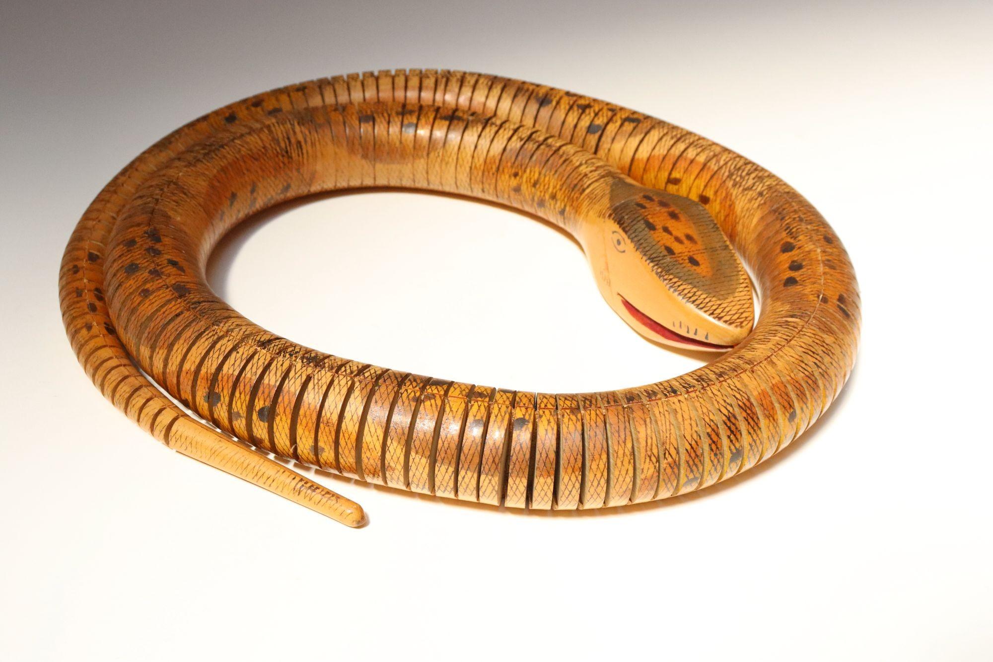Charming folk art carved articulated snake sculpture crafted to mimic realistic snake motion (ca. 1980s, likely South American).
Hand-painted body and facial details present.
Unusually long size - can be extended to almost 5' long (58