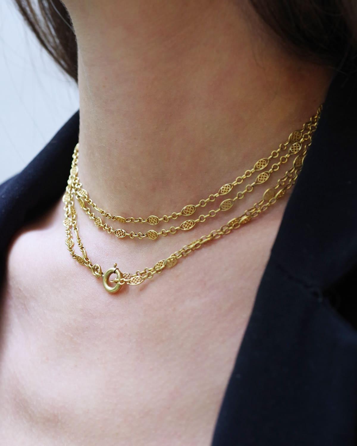 Long collier filigrane ancien en or 18 carats. Le collier se compose d'une double chaîne composée d'une alternance de maillons filigranés et de petits maillons ovales. La double chaîne mesure 75 cm. Fermoir rond en forme de homard. Chaîne ancienne,