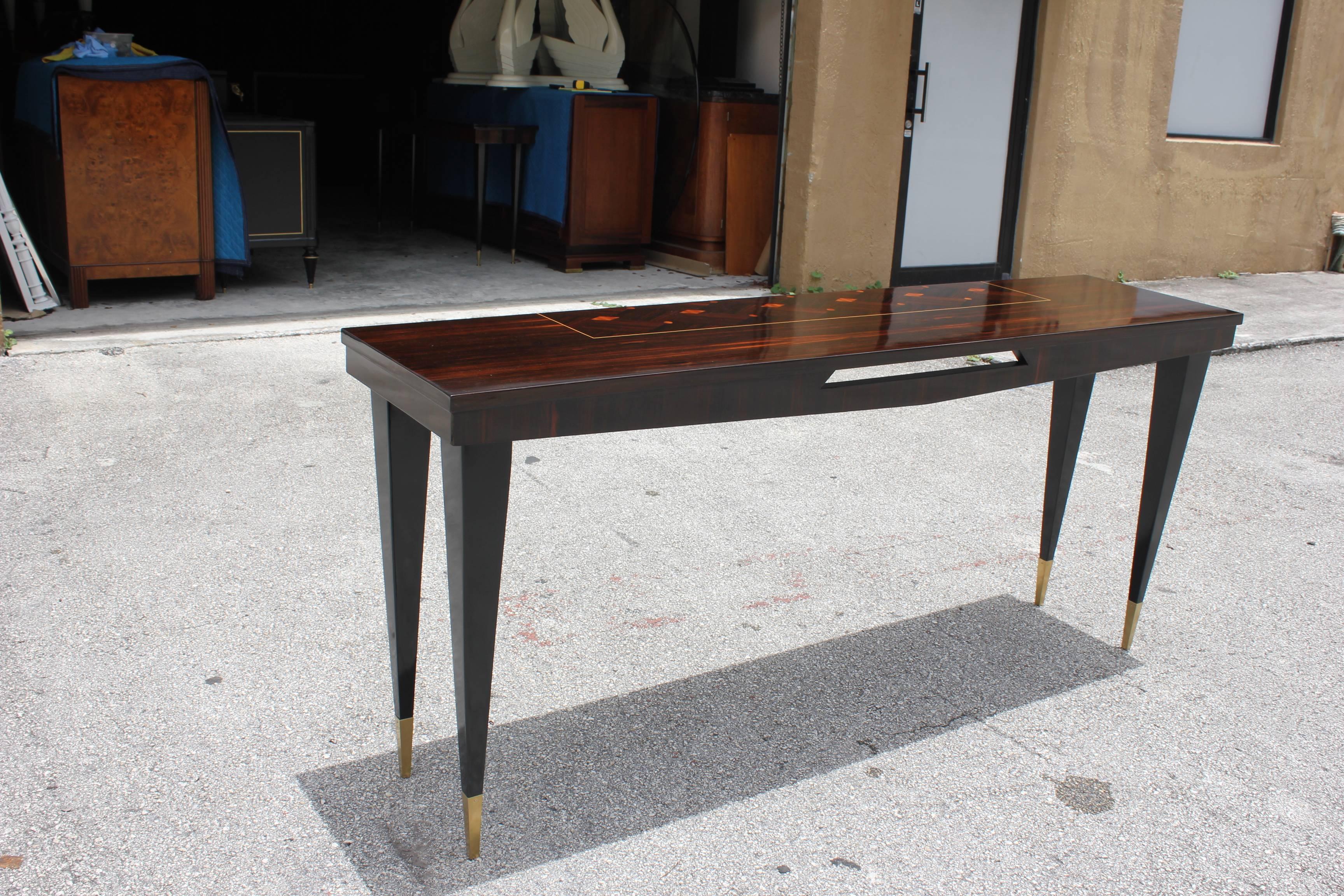 A beautiful French Art Deco exotic Macassar ebony steeped console table, circa 1940s. With black lacquer legs, and brass toe caps with diamond inlaid top, high gloss lacquer finish, the console table are in perfect condition. Size: 66.25 W x 30 H x