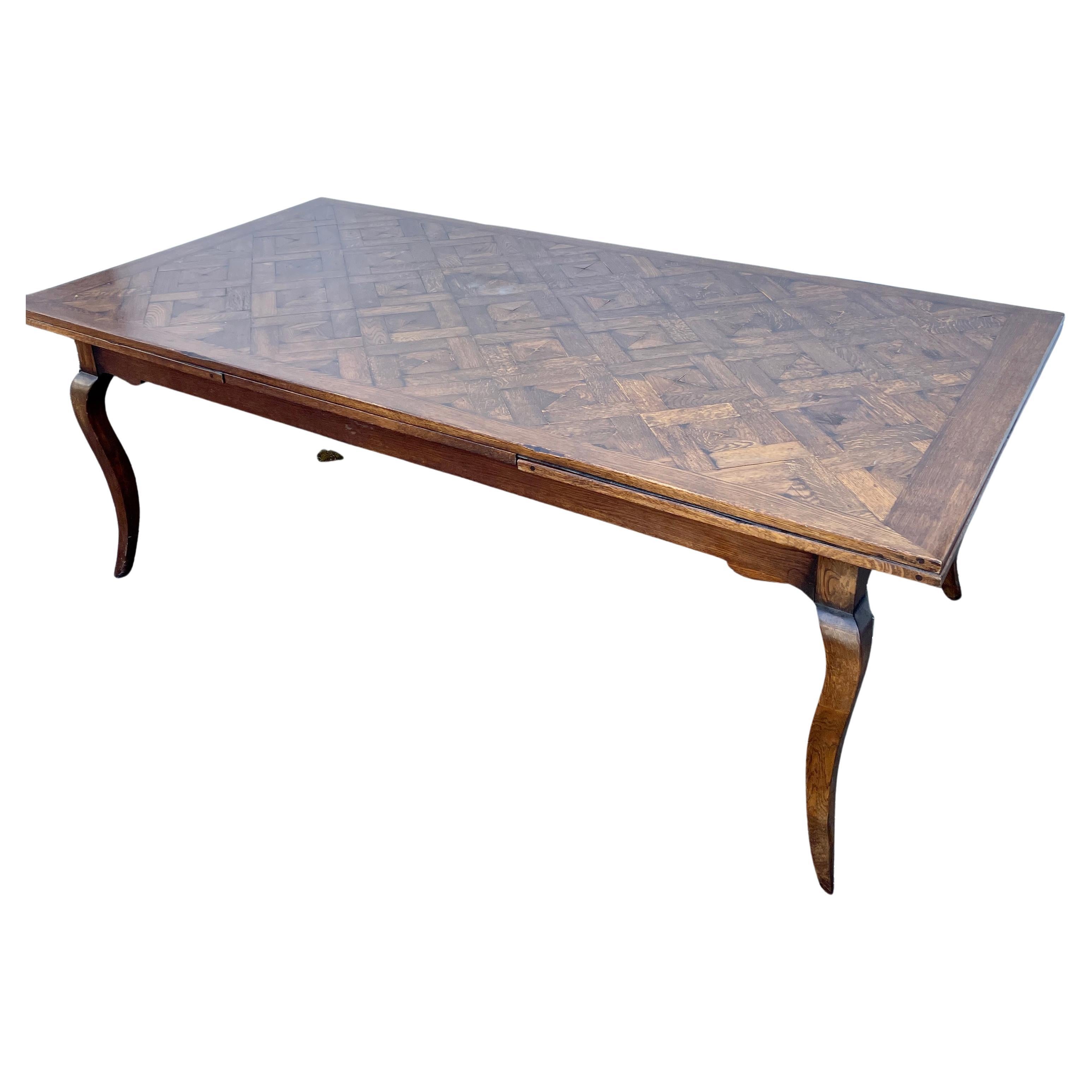 Extra long French provincial style parquet-top extension dining room farm table.

Traditional French Country mixed with the natural beauty of the rustic parquet top makes this handcrafted dining table French Countryside perfection. The natural aging