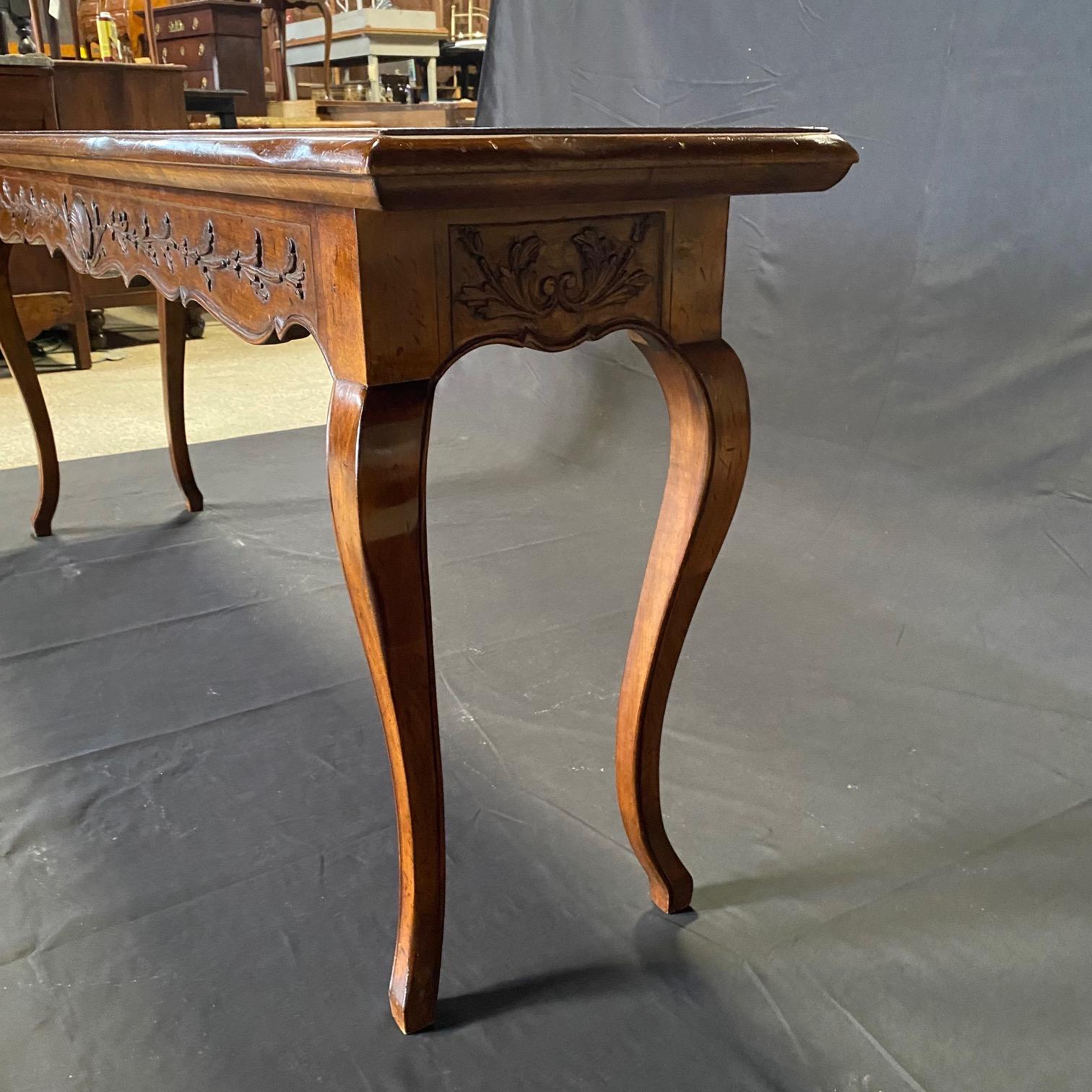 French Provincial console, buffet or sofa table beautifully carved with shells and floral leaves, bought in the South of France. This beautiful piece is carved on all four sides, so can be in the middle of a room; carved front, back and sides with