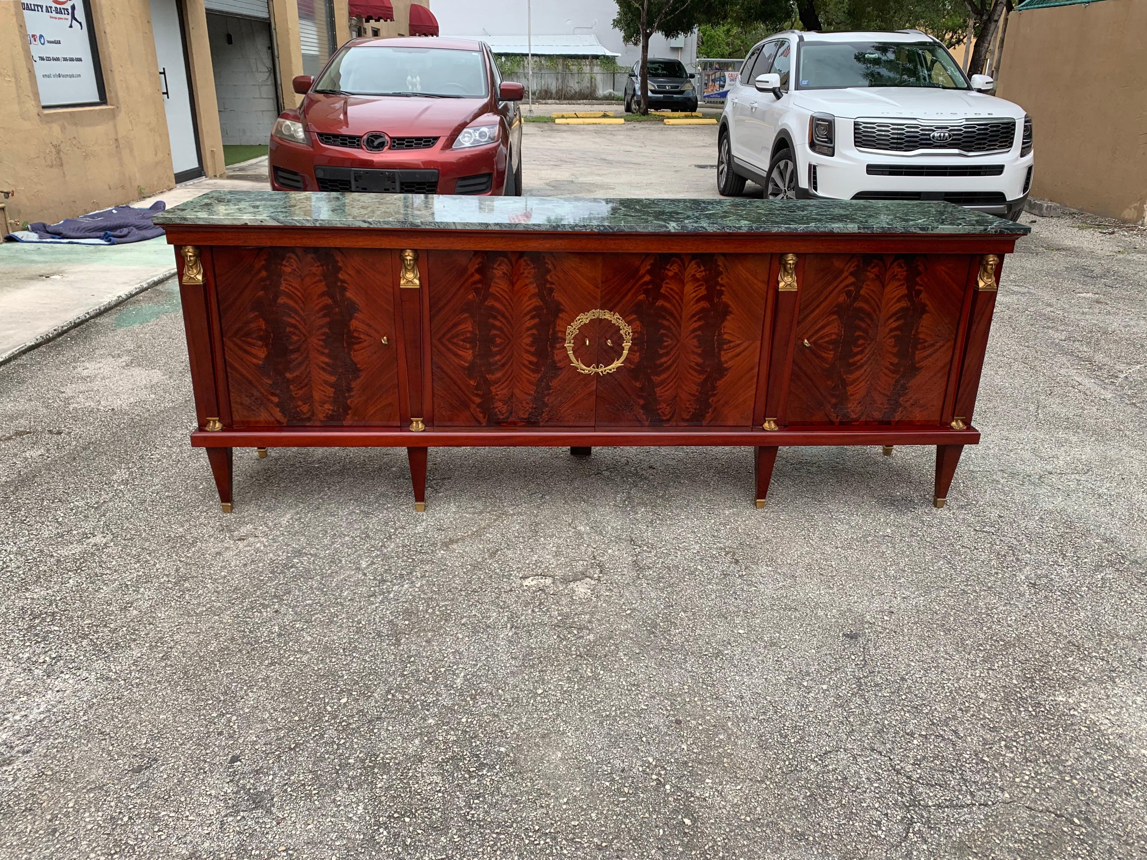 Long French antique Empire sideboard or buffet made of mahogany with a beautiful green marble top, the mahogany wood has been finished with a French polished high luster inside and outside, the buffet has 4 doors, and 4 drawers inside With all 4