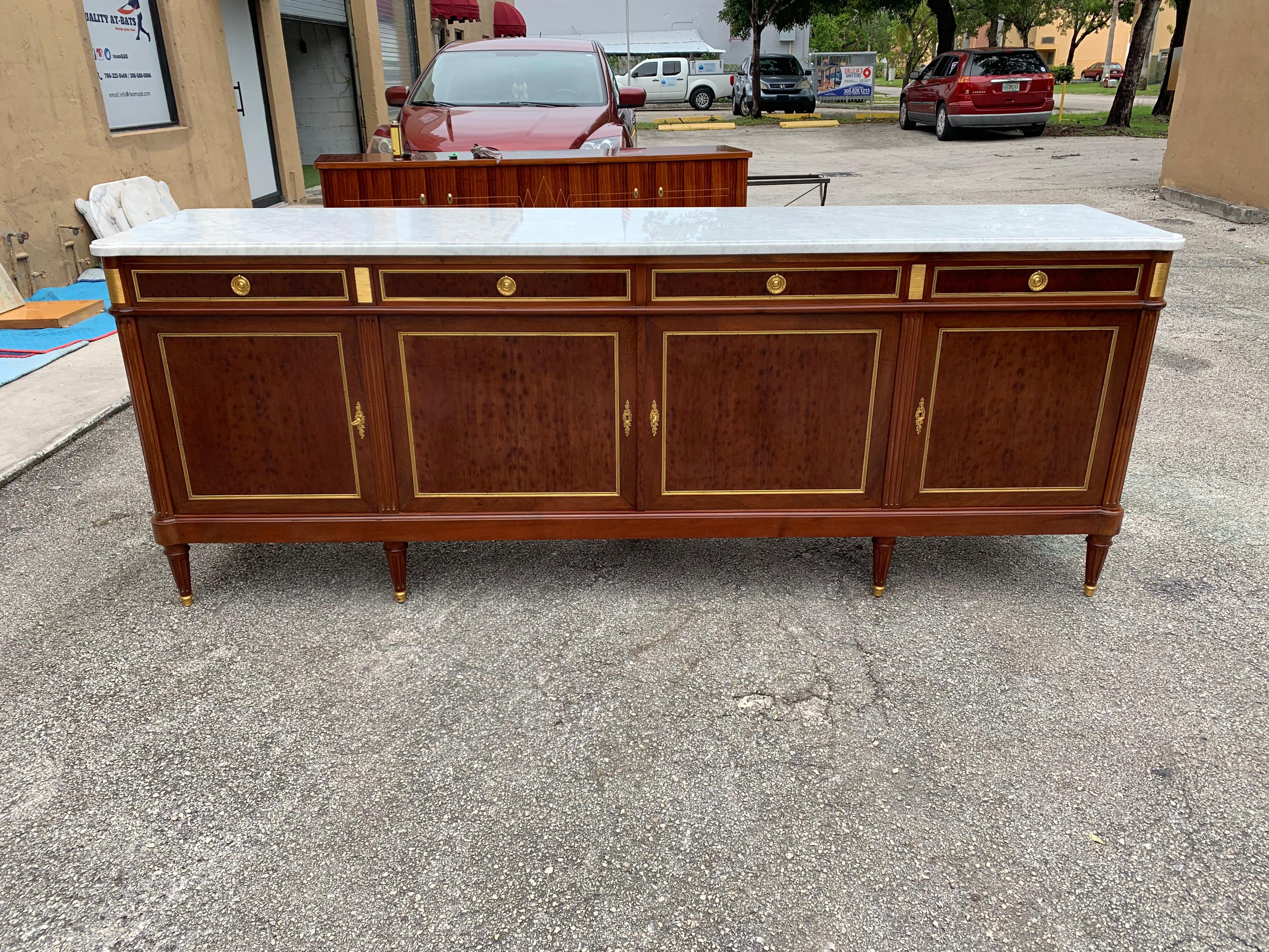 Long French antique Louis XVI style sideboard or buffet made of mahogany with a beautiful Carrara marble top, the mahogany wood has been finished with a French polished high luster inside and outside, the buffet has 4 doors and 4 drawers, with all 6
