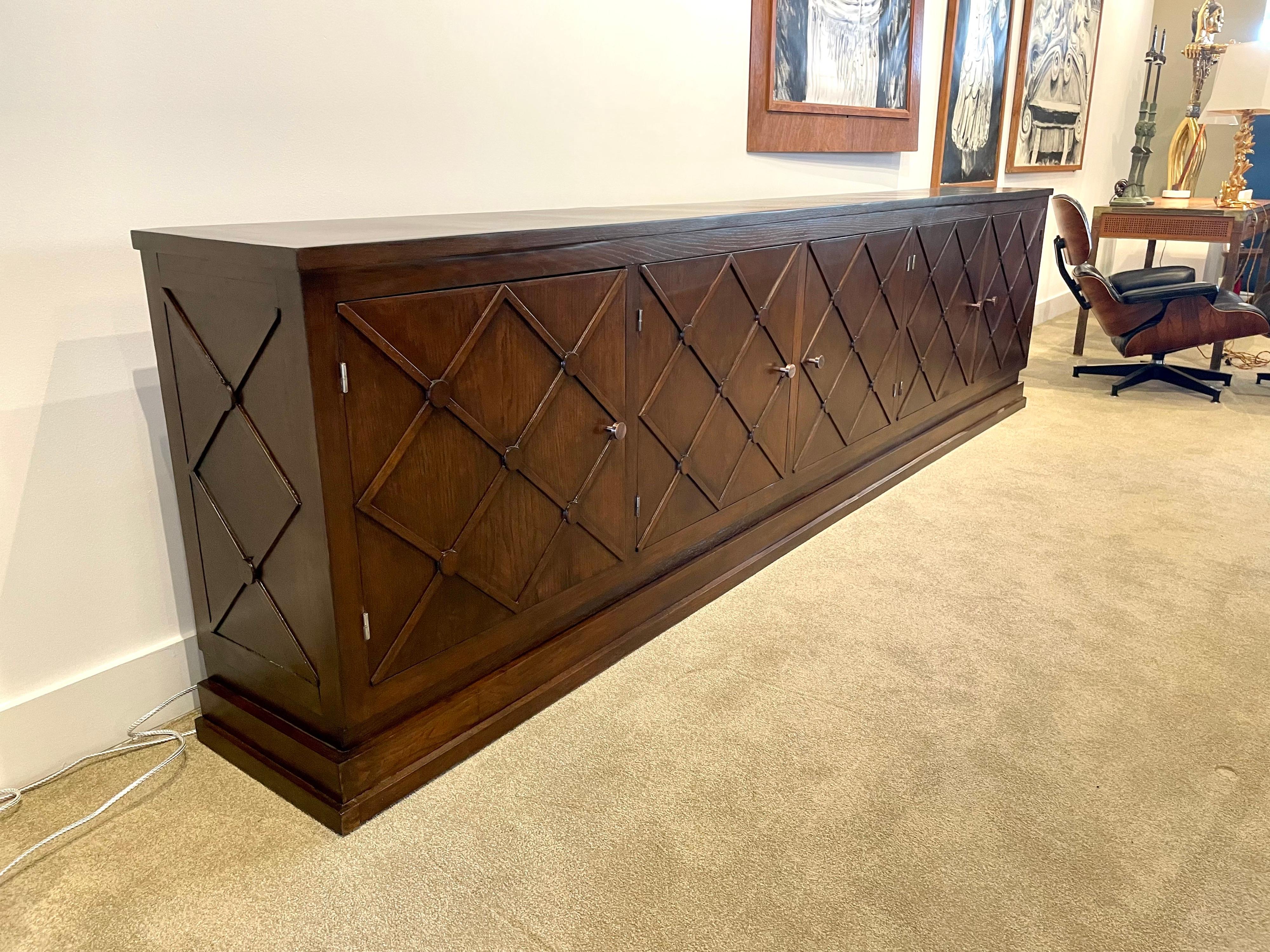 This piece is an extra long latticed cabinet from the 1940s in the style of Jean Royère. 5 doors open to open shelving. Incredible vintage condition. This piece is available NOW and ready to ship from Miami, FL.