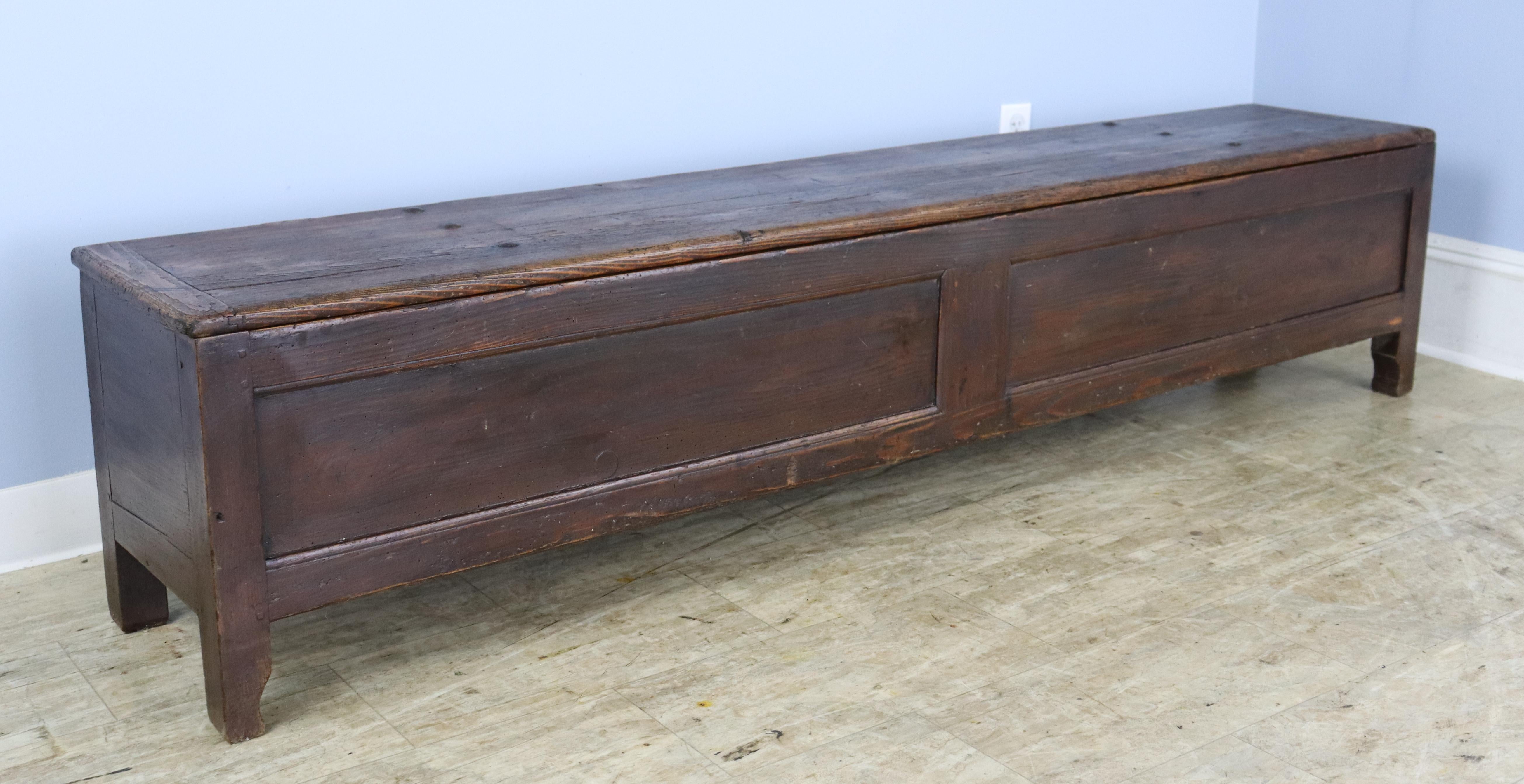 An antique coffer from France with unusaual length. The pine is a deep, rich color with vivid graining. Top lifts off for good storage, divided into two compartments. . Great at the foot of a bed, underneath a window, or in a long hallway.  The