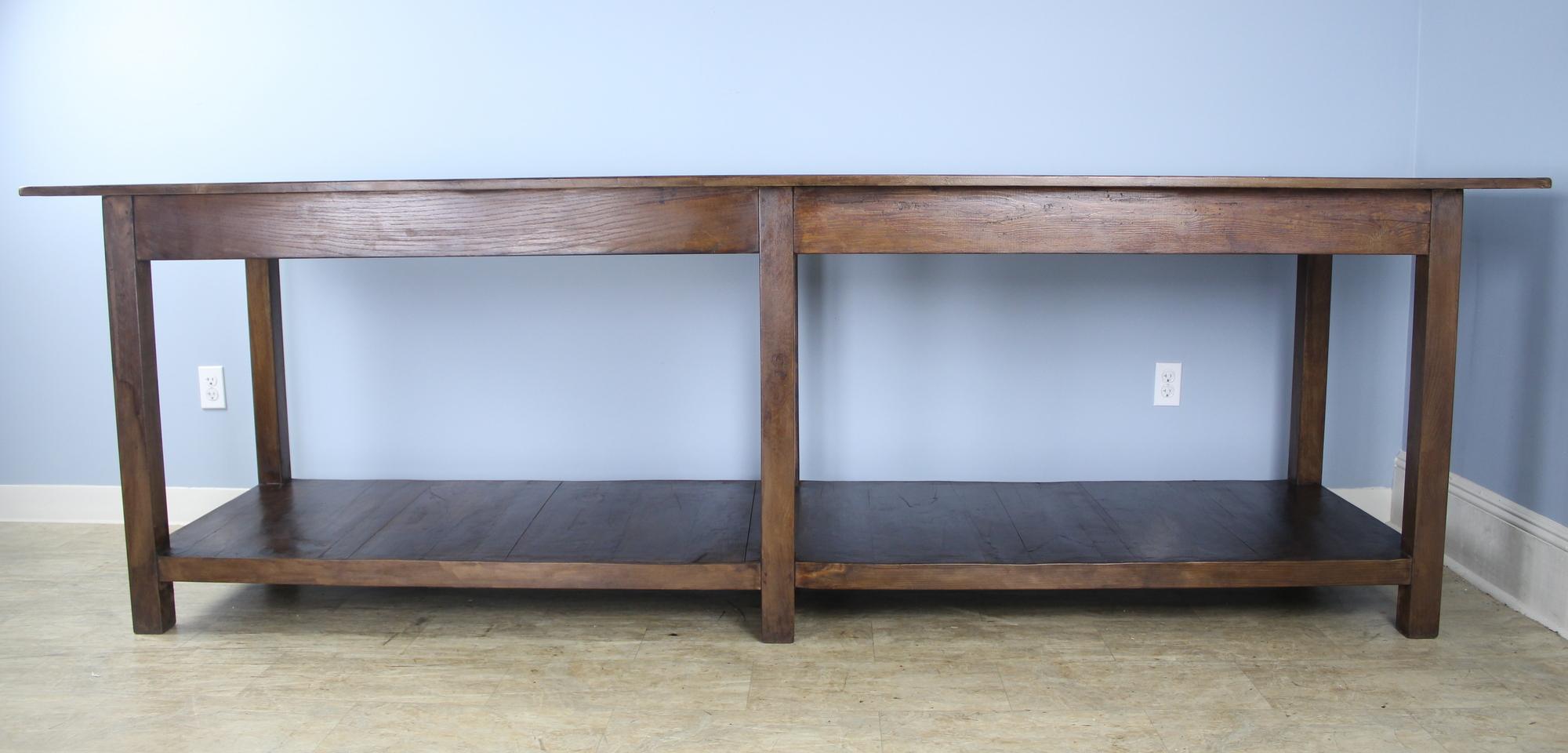 A very long, fabulous French fruitwood draper's table. This type of table was originally for use by a tailor or seamstress. Legs have good Solid style and nice patina. Top has been finished for a smooth clean look. Would work well as a room divider