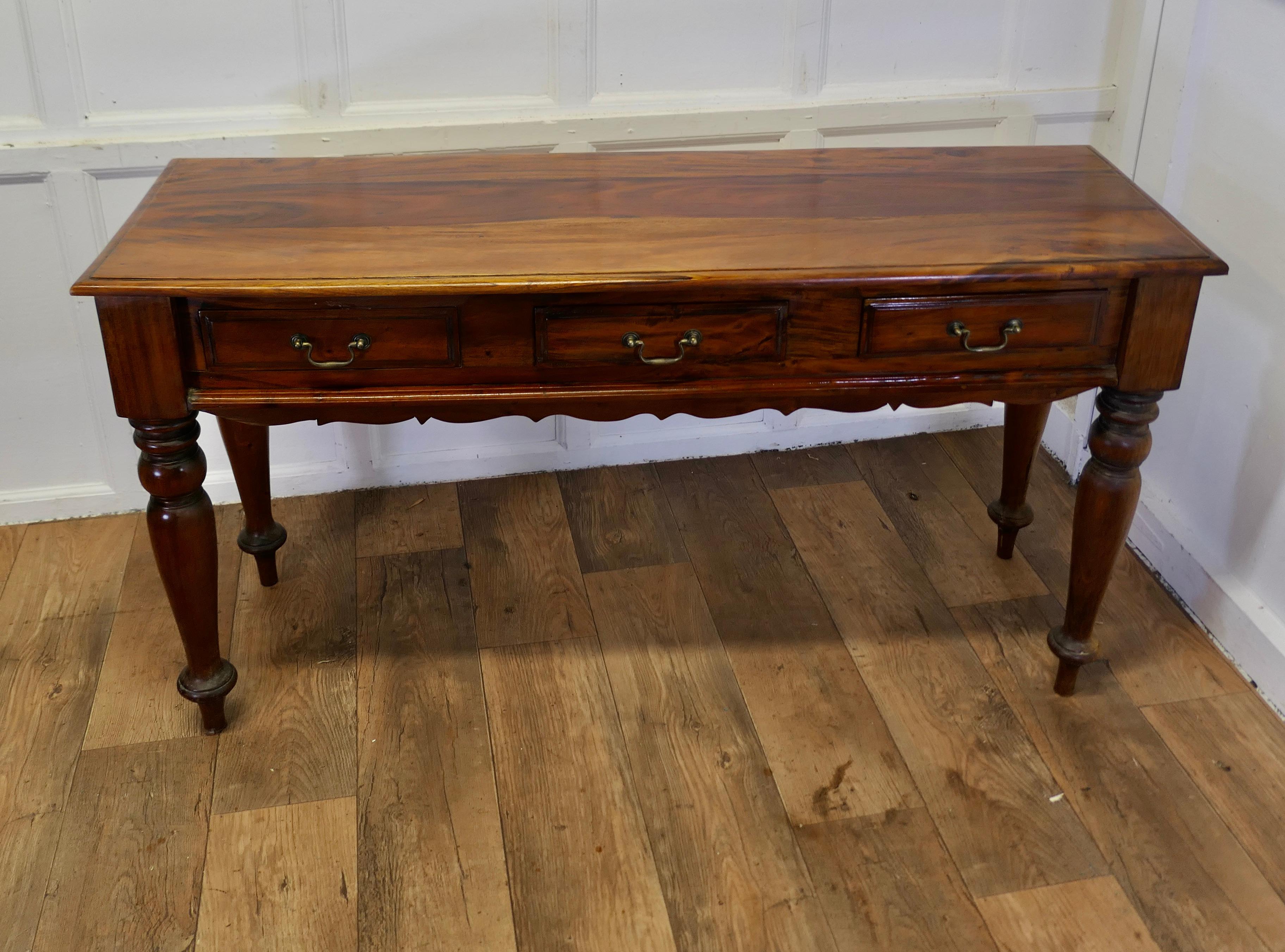 Long Fruitwood Hall Table, Serving Table

This is a very attractive piece it is made in fruitwood which has a very attractive grain and patina
The table is set on chunky turned legs and has 3 drawers to the front with a scalloped apron beneath, it