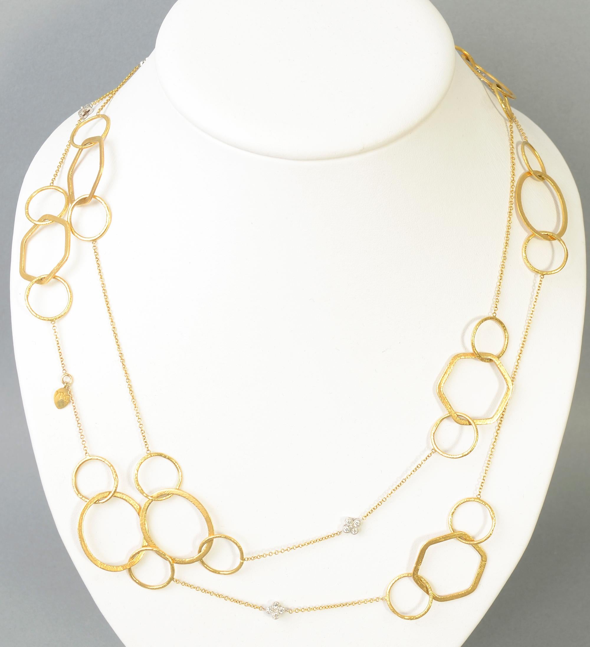 Most interesting and unusual long gold chain necklace with diamonds. The links are round; oval and hexagonal. It has 6 clusters of four diamonds each. The necklace is 52 inches long so it can be worn singly or double. There is no clasp. It has a