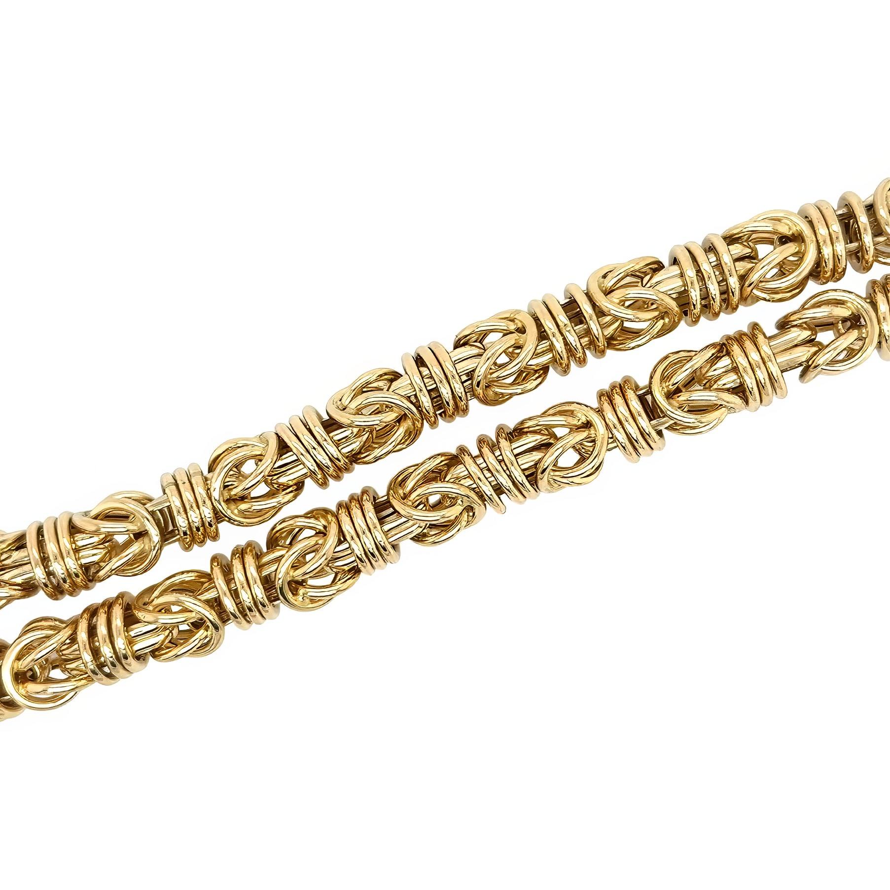 A 14 karat yellow gold necklace.  Designed as a modified Byzantine chain, each link embellished with three 
