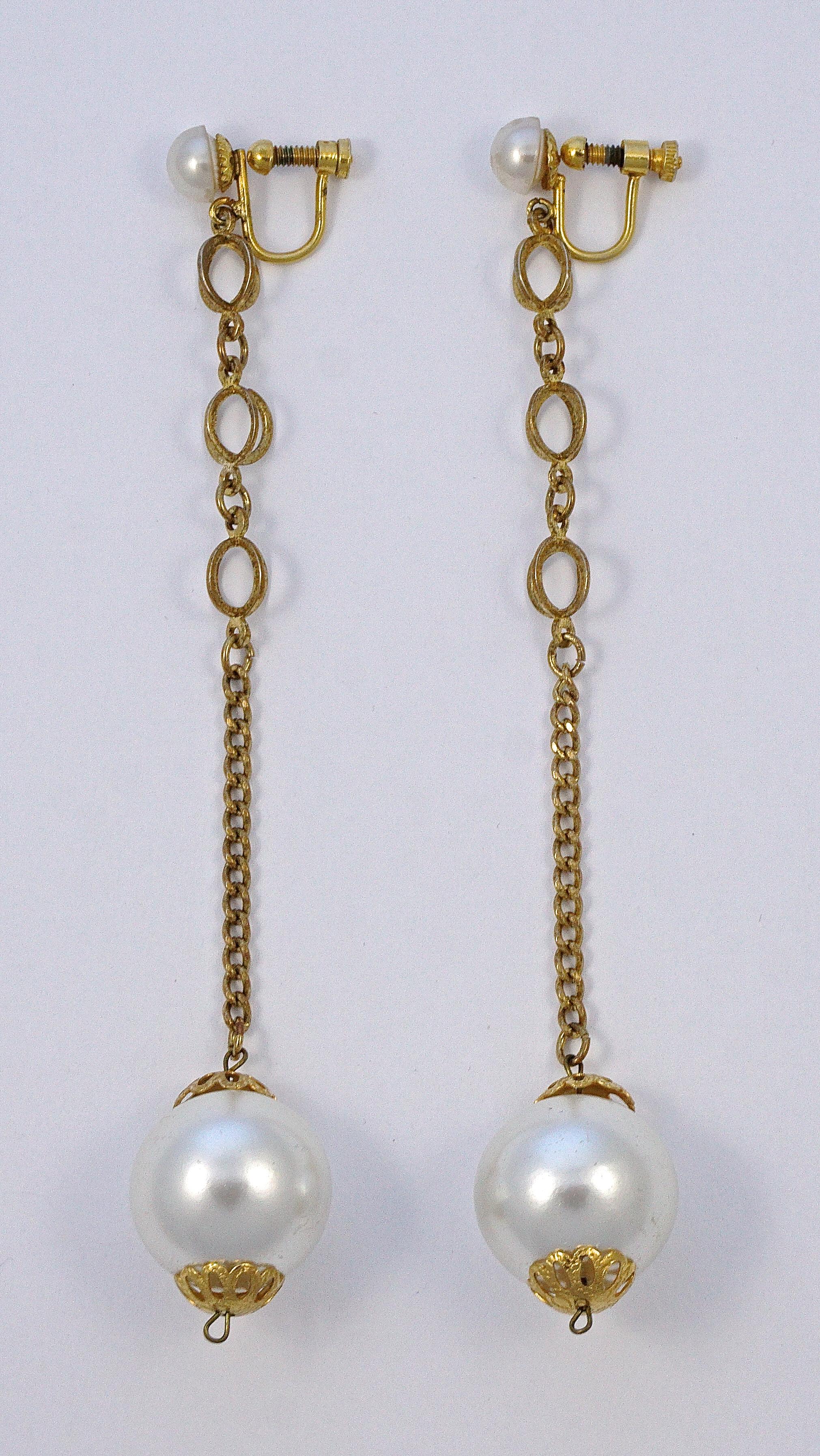 Stylish long gold plated dangle screw back earrings, featuring a circles design, and white faux pearls. Measuring length 12.5cm / 4.92 inches, and the pearls are 1.9cm / .75 inch. There is some wear to the gold plating and faux pearls.

This is a