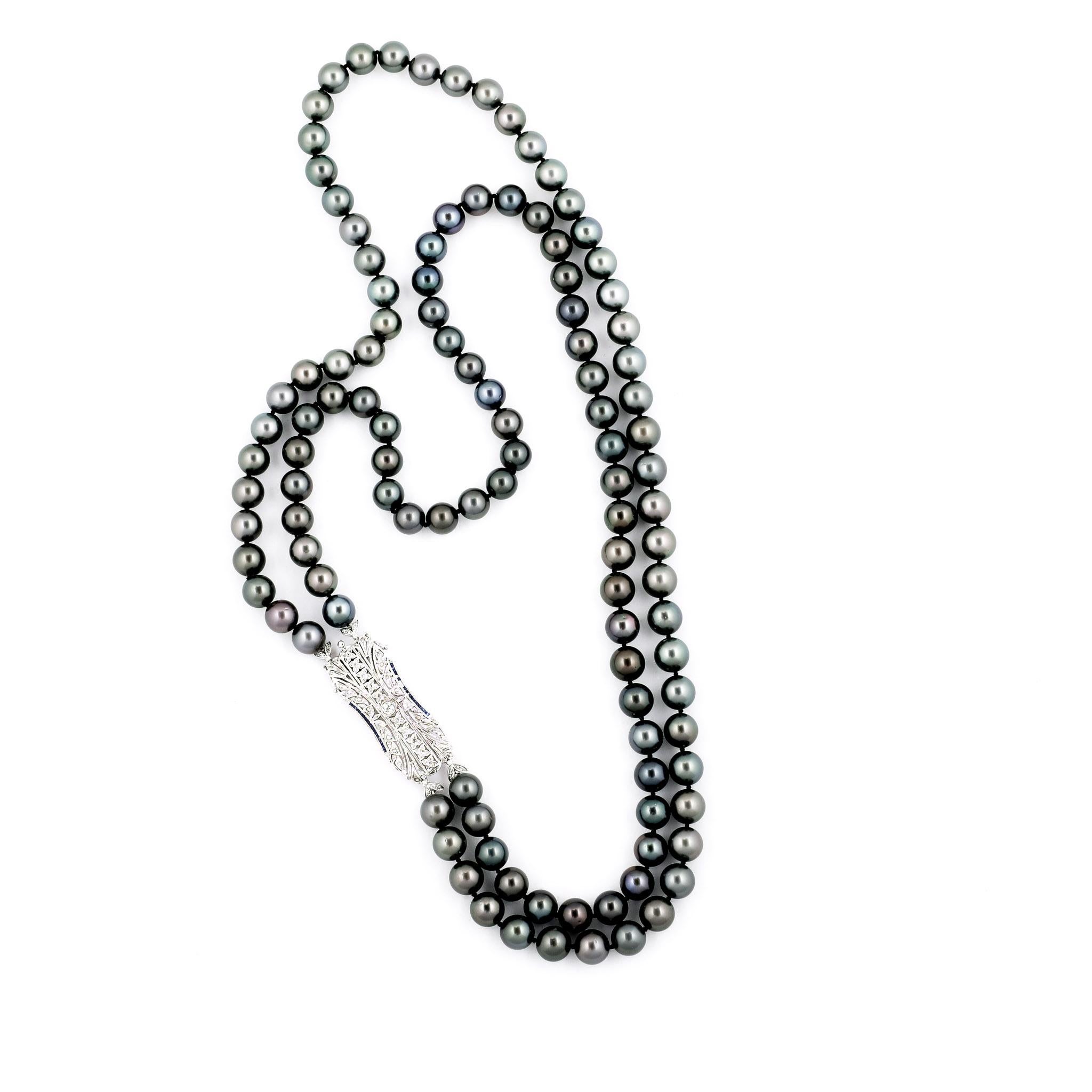This stunning necklace is compromised of 112 outstanding approx. 12 mm high quality Tahitian pearls. 
It is set with an Art Deco Style 18k white gold clasp embellished with 1 carat of Round brilliant cut diamonds and mixed cut blue sapphire. Pearls