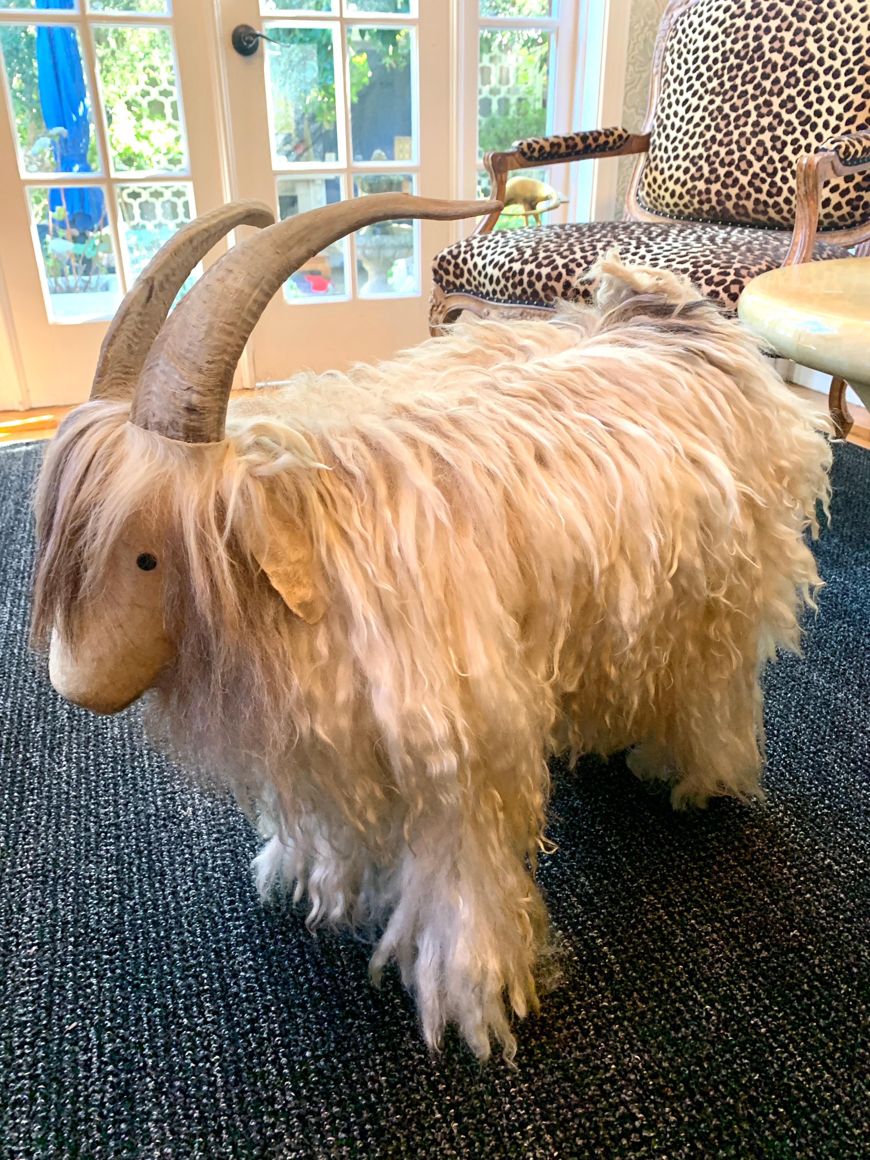 A wonderful ottoman, stool or sculpture in the style of famous French sheep.   The sculpture is covered in real long hair fur, real horn or antlers and a hide covered face. The hoof feet are black painted wood. A stunning conversation piece that