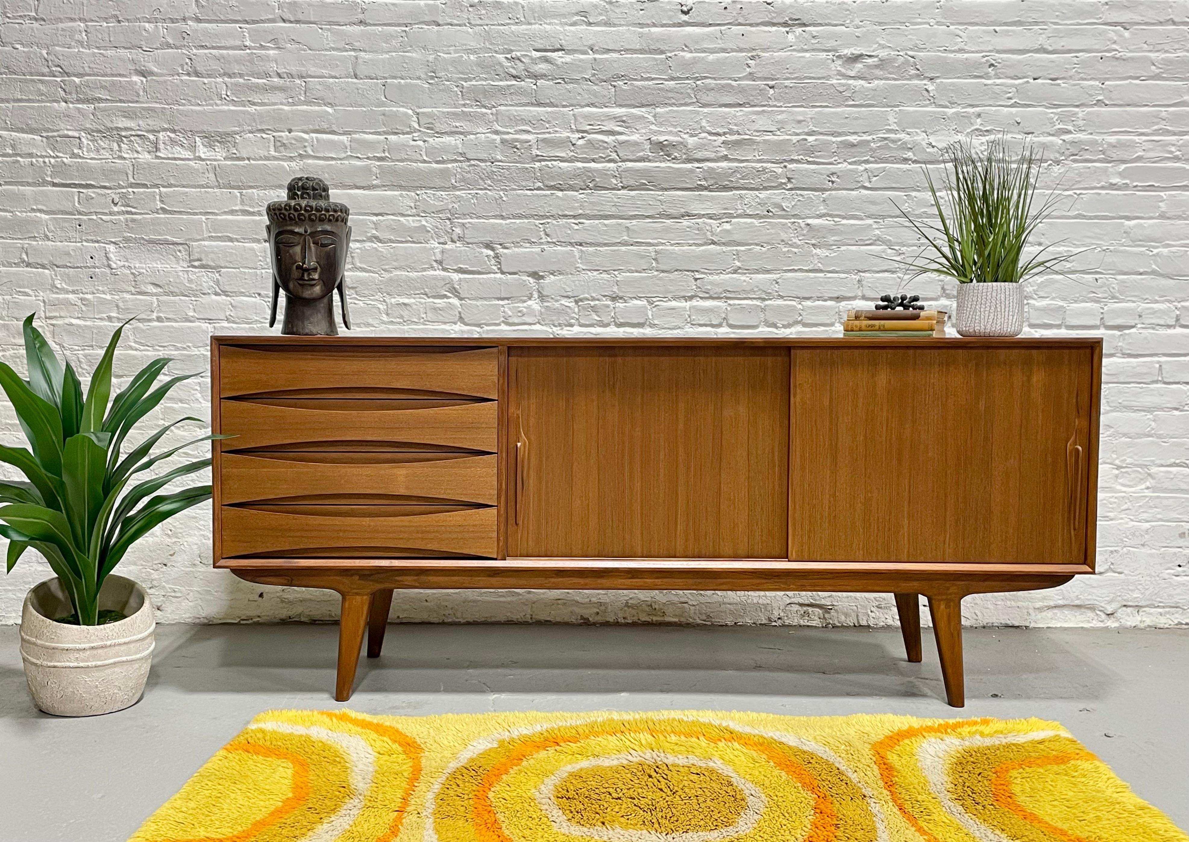 Long Mid Century Modern styled handcrafted Credenza / Media Stand. This beauty features exquisite knife-edge hand pulls and sculpted drawer fronts with slightly splayed legs. Stunning wood grains and finished back allow you to float the credenza in