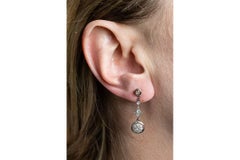 Long hanging 18-karat gold and platinum earrings with diamonds.