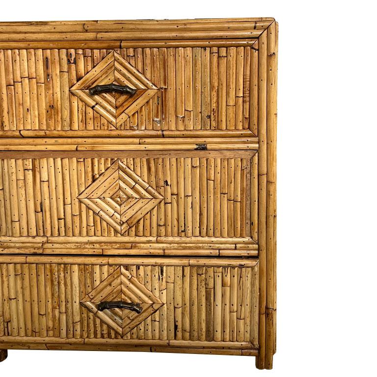 A Hollywood Regency split reed bamboo dresser. This dresser is long and rectangular and created from wood. the top and sides are decorated with split reed bamboo in a geometric diamond pattern. The dresser features six pull-out drawers. The joints