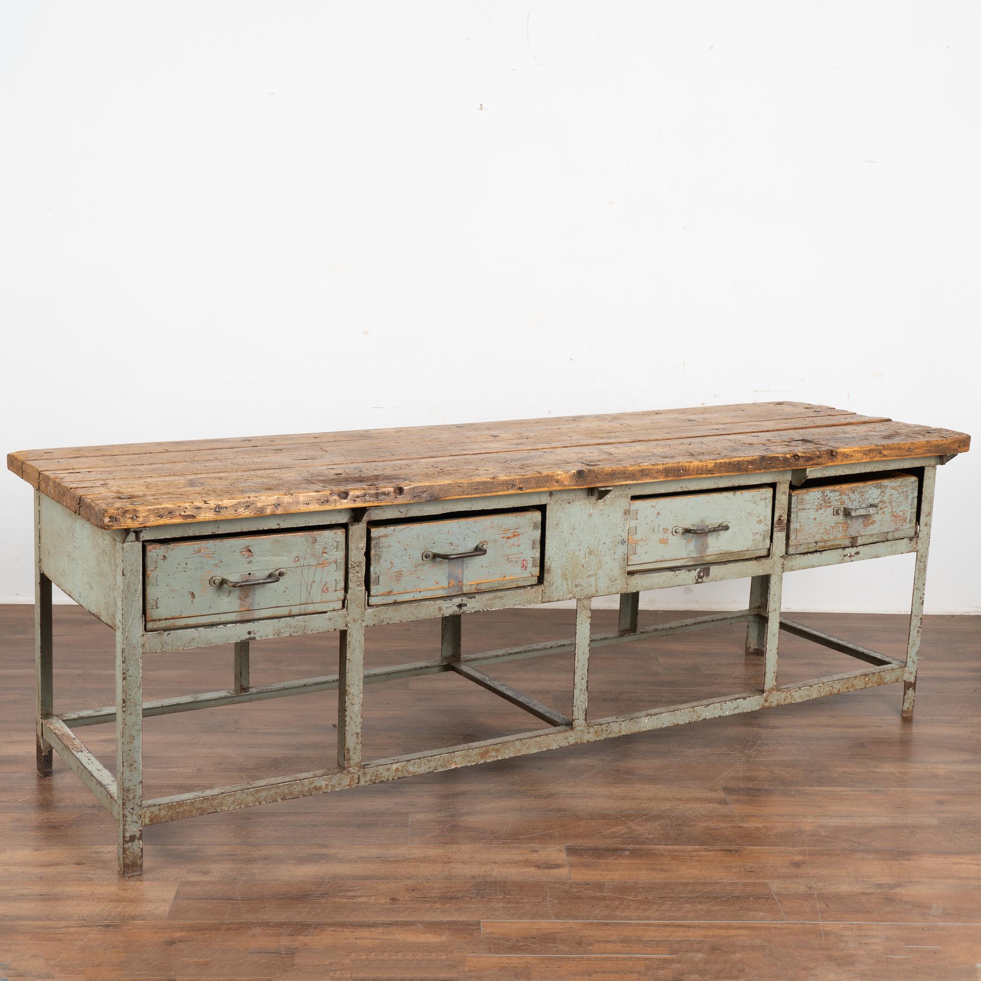 This long rustic work table is a great find at almost 8' length with an industrial painted metal base, rugged wood top and deep wood drawers.
The generations of use are revealed in every nick, gouge, stain, hole and crack that add to the deep