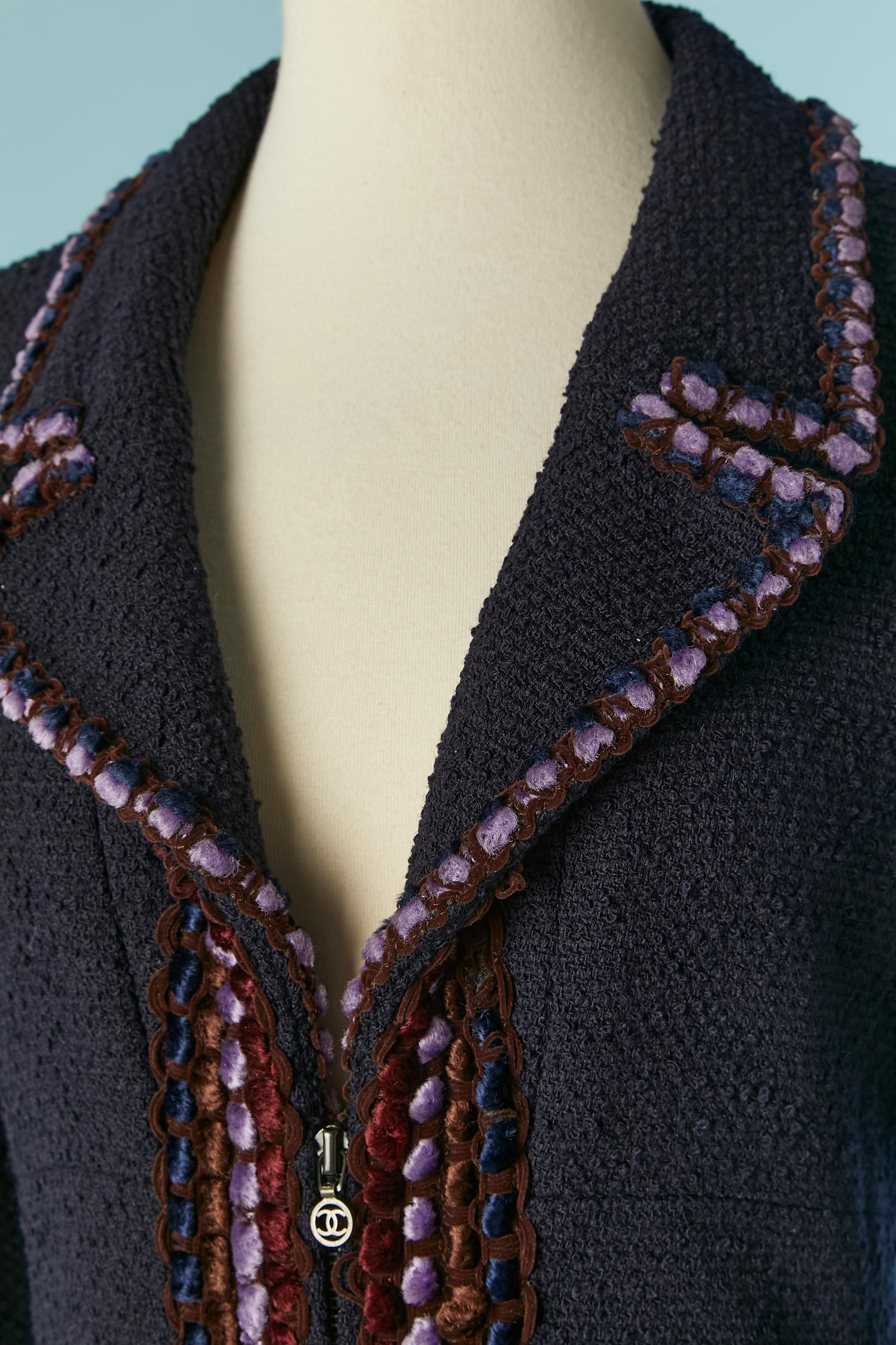Long jacket in Navy tweed with velvet trims and zip closure in the middle front with branded zip puller.  Main fabric composition: 88% wool, 12% nylon. Silk branded lining: 95% silk, 5% lycra. 
Shoulder pads. Chain inside in the bottom edge. Pocket