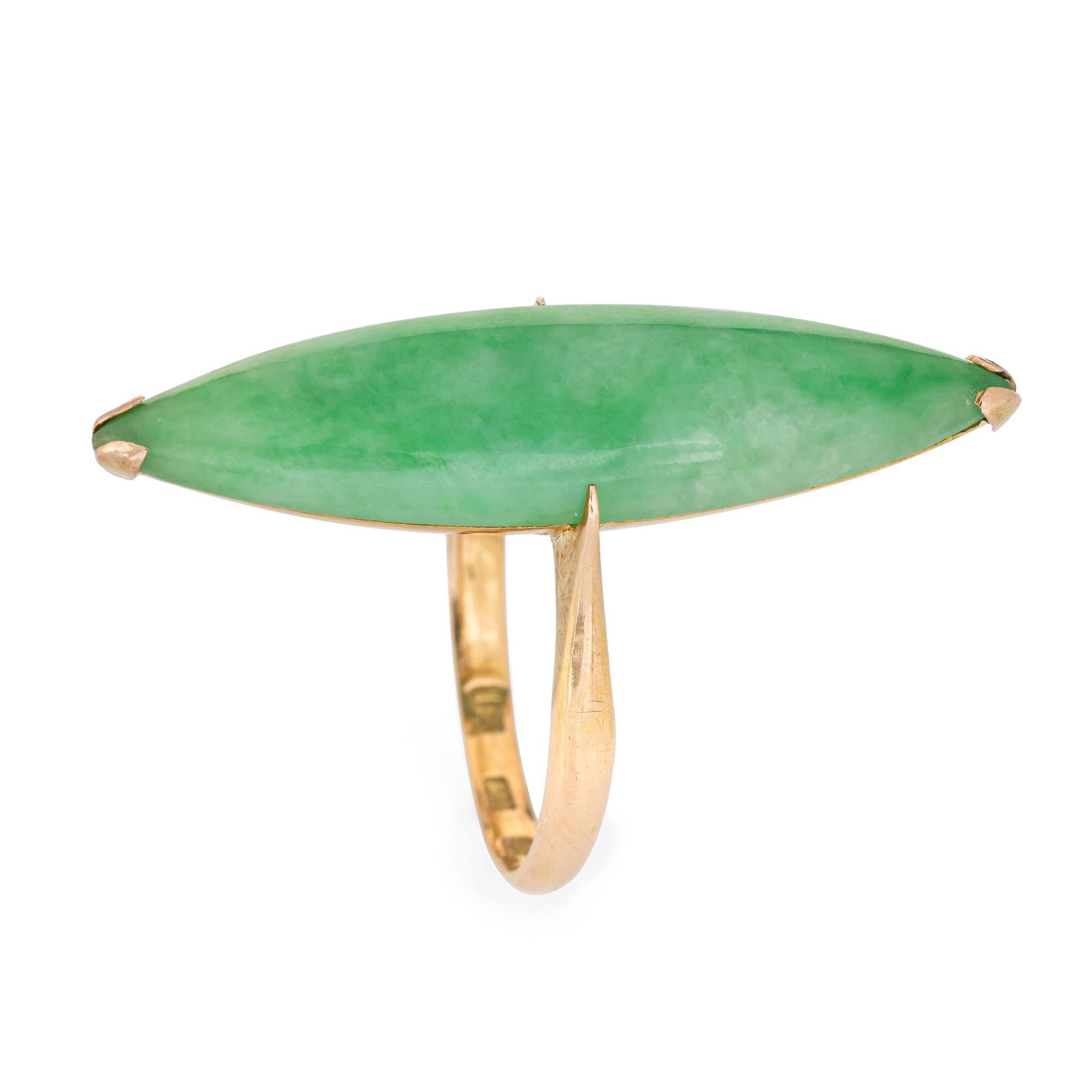 Finely detailed vintage elongated green jade cocktail ring, crafted in 18 karat yellow gold (circa 1960s to 1970s). 

Cabochon cut marquise shaped Jade measures 35mm x 9mm (in very good condition and free of cracks or chips).  

The long cocktail