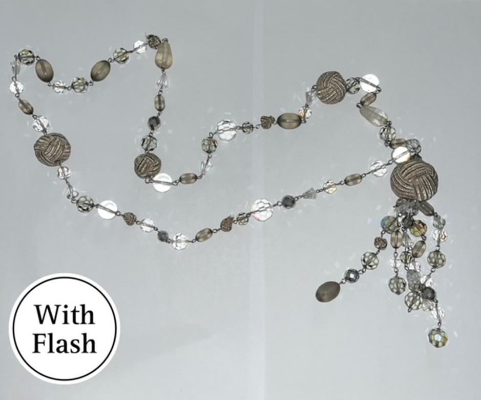 Questa splendida collana in stile lariat è una creazione di Daniel Swarovski. Questa collana dai toni neutri presenta perline metalliche argentate intricatamente intrecciate e accenti cristallini e scuri smerigliati. L'esclusivo design del ciondolo