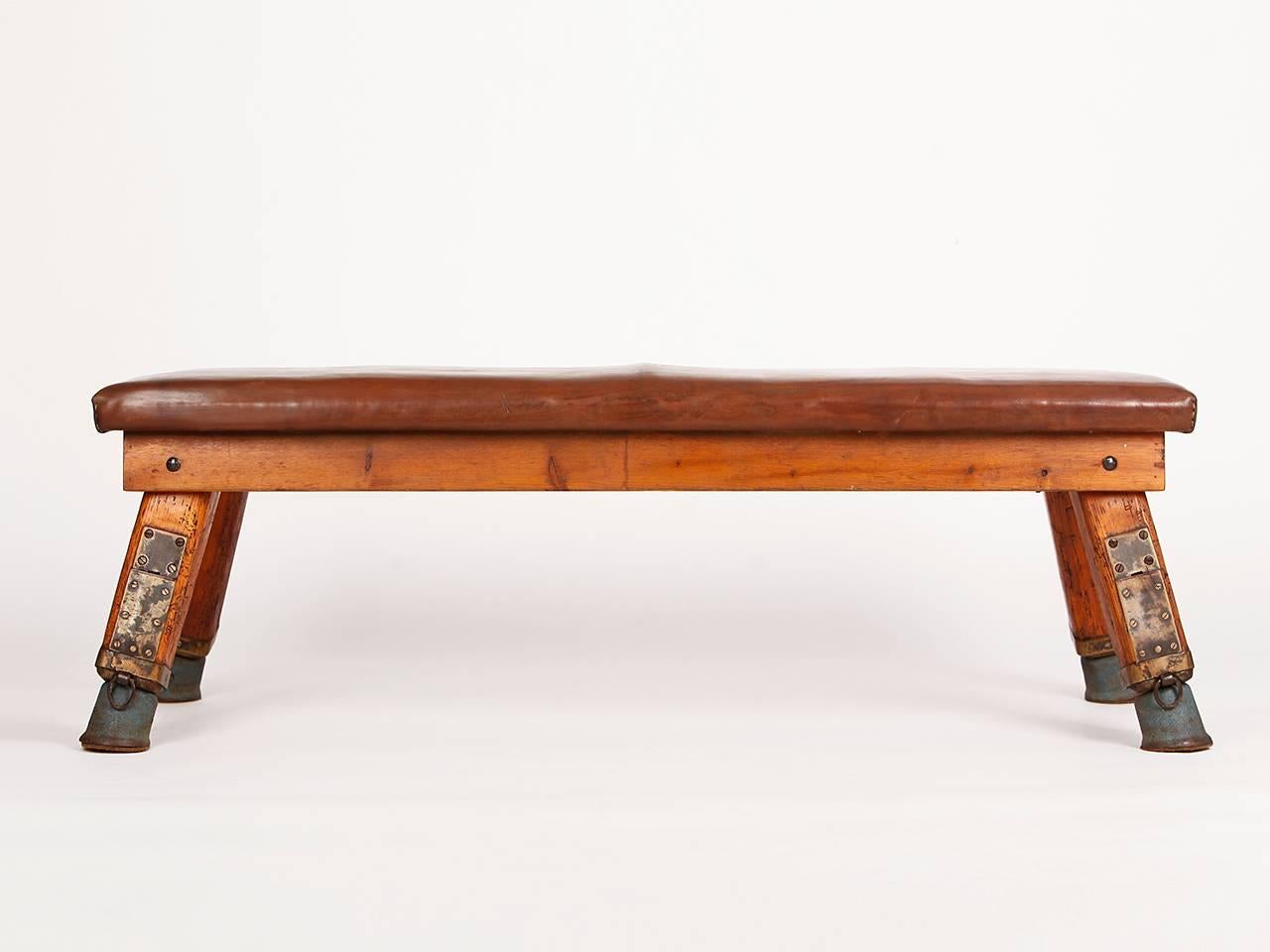 This gymnastics bench comes from a gym in Prague and was designed in the 1930s. The iron feet have been preserved with original cow leather lining. The thick cowhide has been cleaned and preserved and has a very nice patina.
 