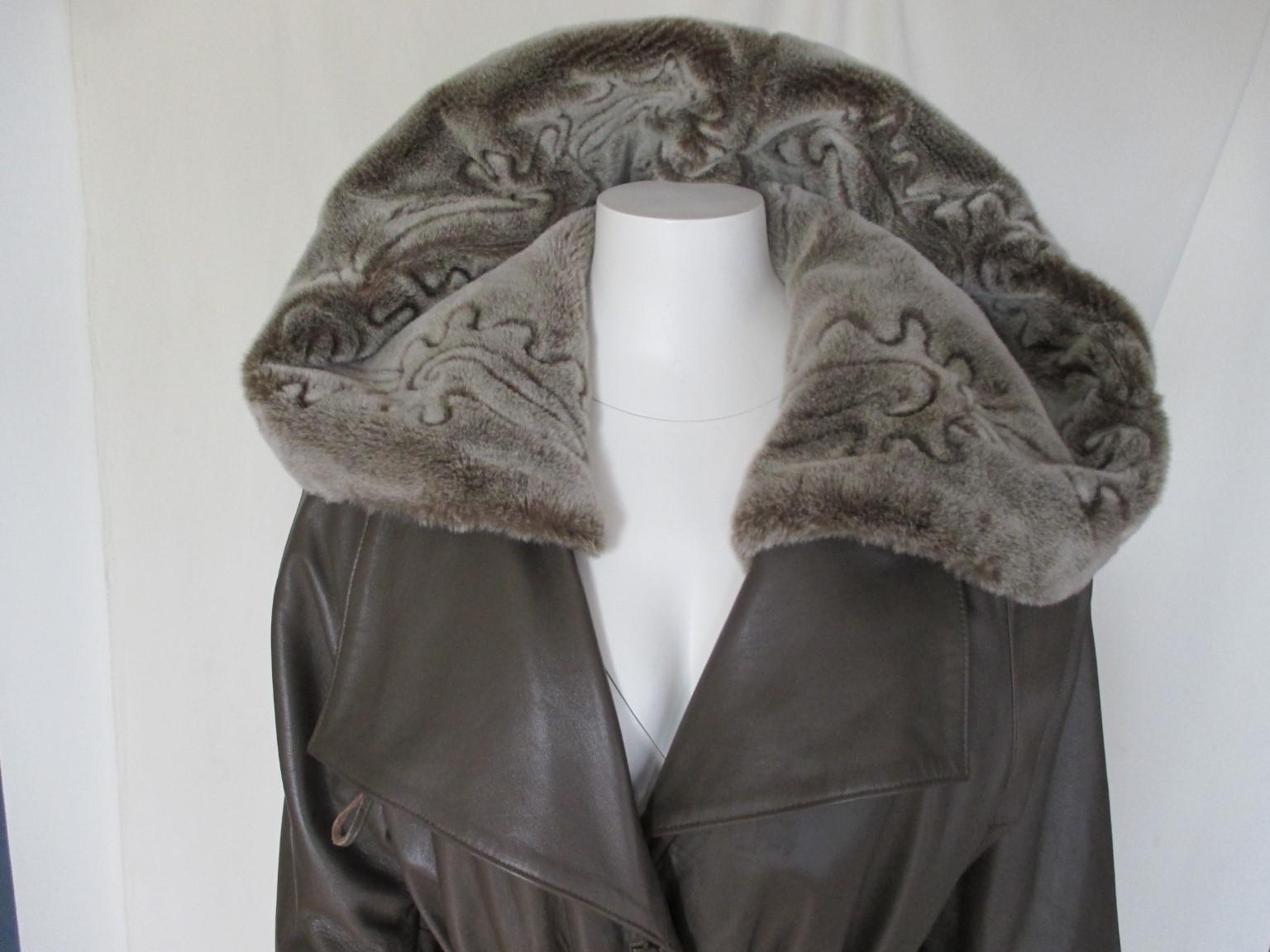 Amazing vintage coat from brown quality leather with a faux fur collar hood and faux fur cuffs with a matching leather belt.
Hood and cuffs are detachable with buttons and a second grey lining with a zipper.
2 pockets, 3 closing buttons and 1 button