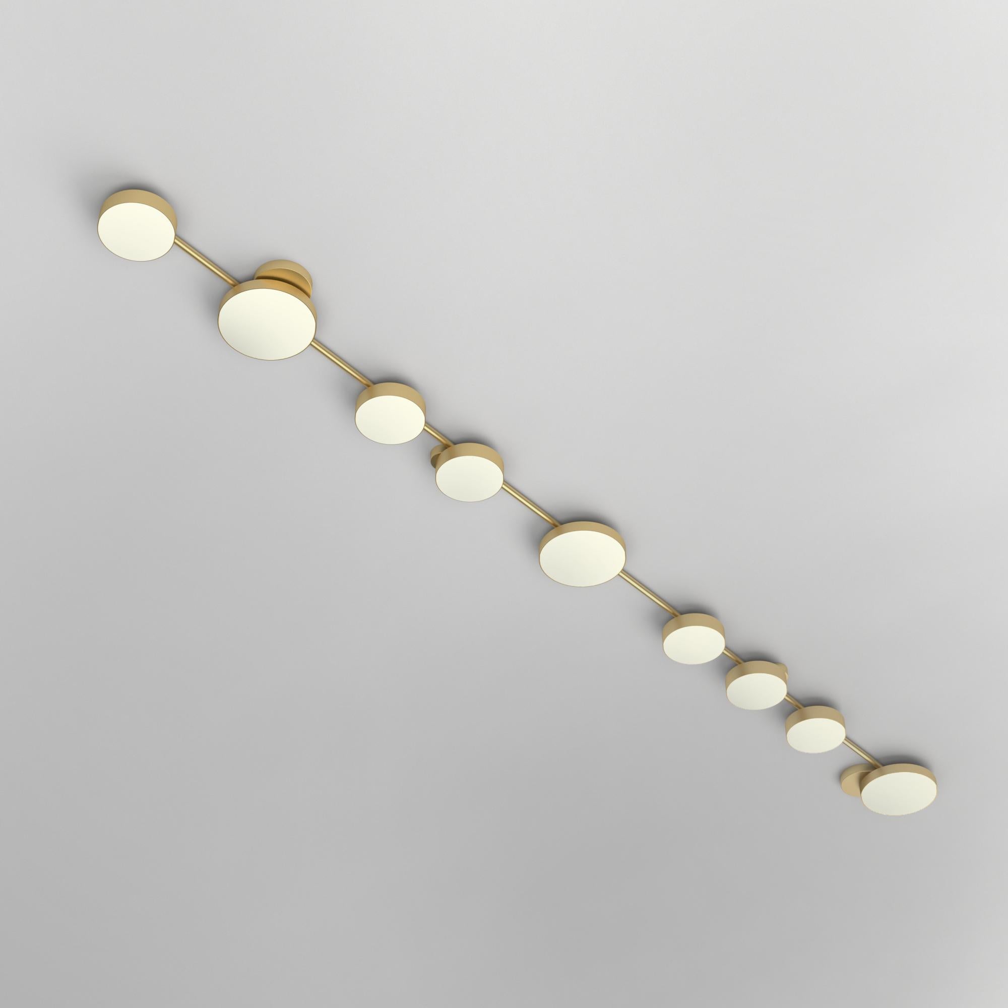 Long Line, 9 Circles, Ceiling Light by Atelier Areti
Dimensions: D 15.3 x W 279 x H 6 cm.
Materials: Brushed brass, white glass.

All our lamps can be wired according to each country. If sold to the USA it will be wired for the USA for