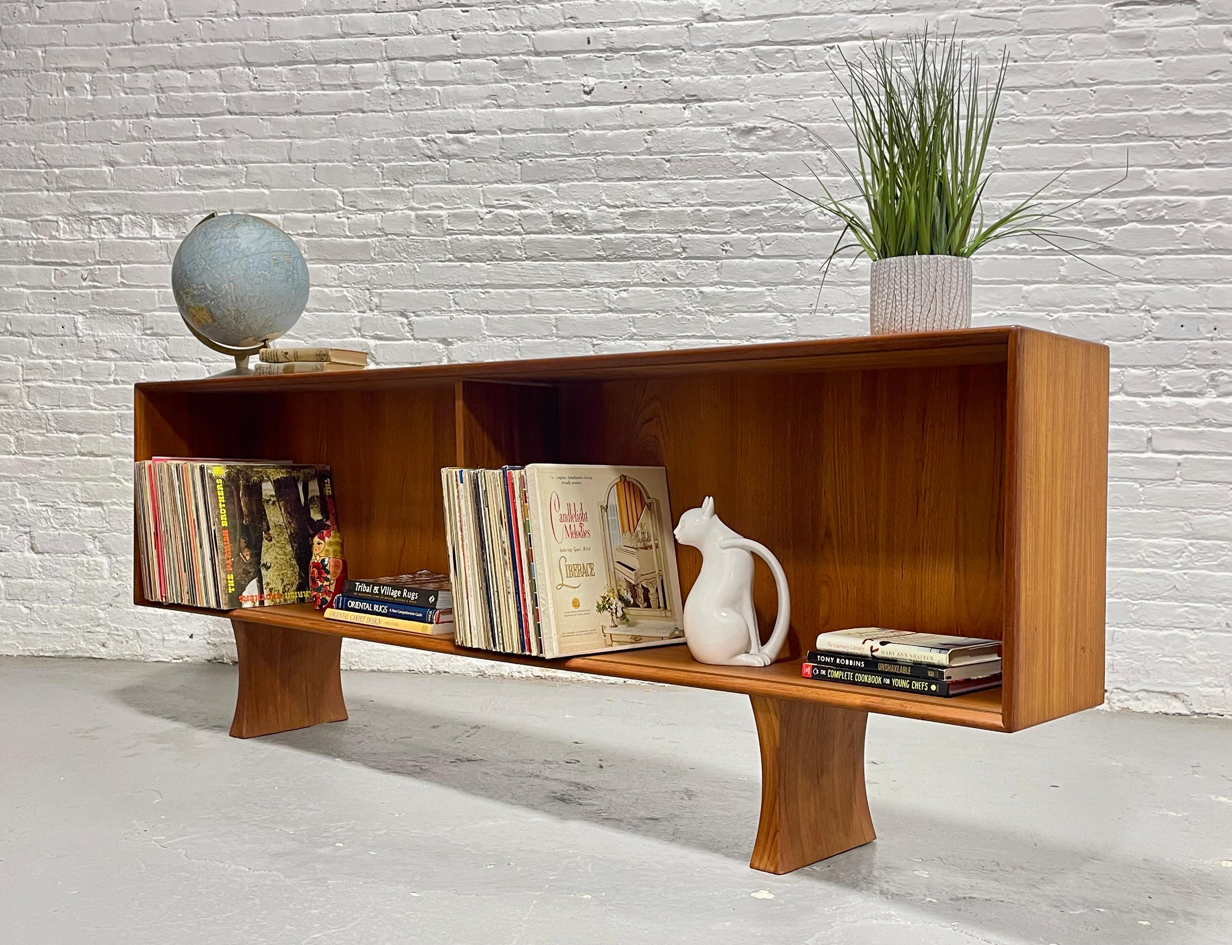 Mid Century Teak Danish Bookcase / Credenza - Made in Denmark, c. 1960's. Plenty of room for books or your record collection with rich and stunning wood grains. Chunky teak legs are solid and give this piece a floating appearance.  The console is