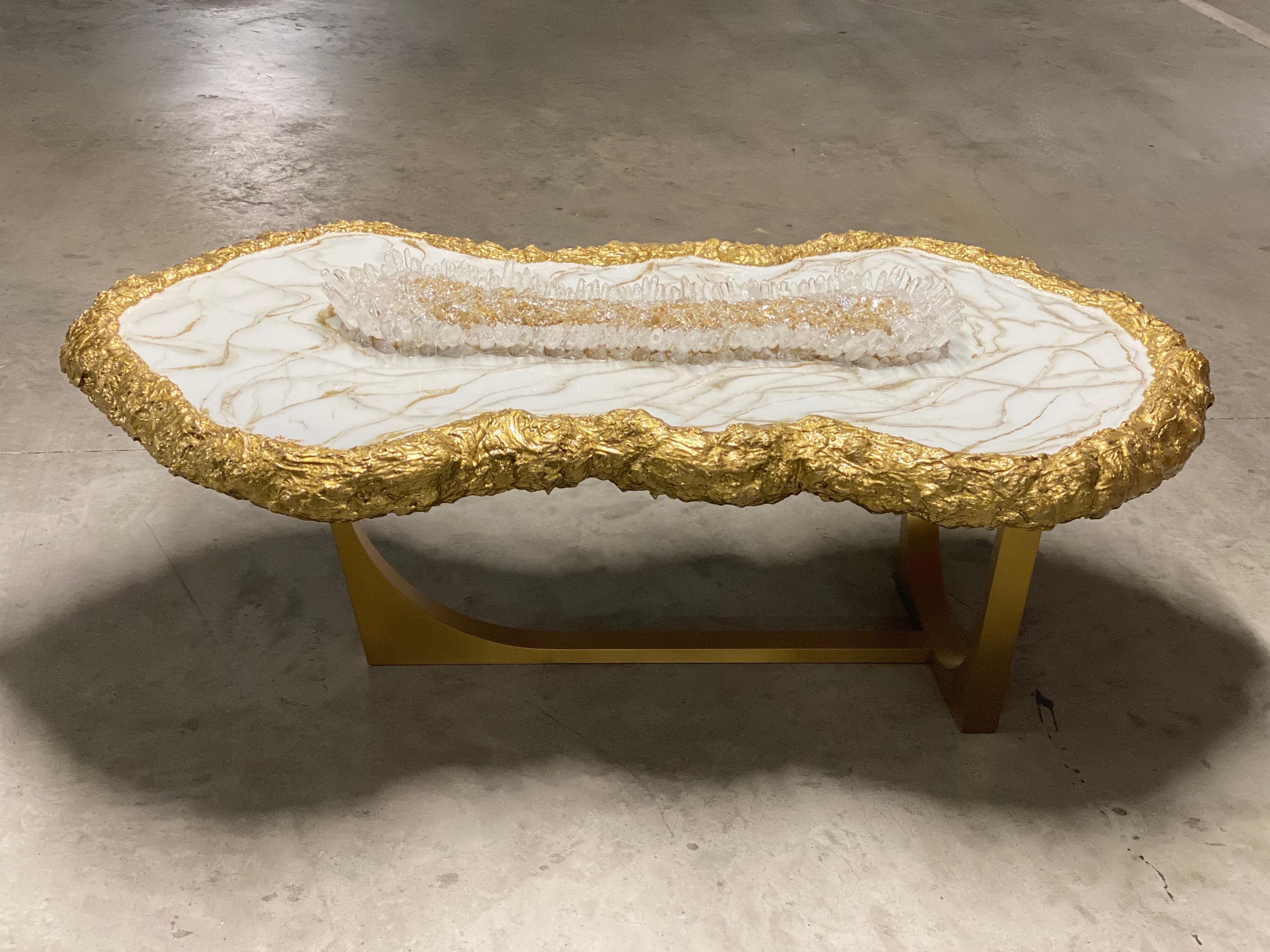 TISCH AUS WEISSEM MARMOR UND GEODEN

Schauen Sie sich unseren herrlichen Couchtisch an! Sie ist mit natürlichem Quarz und reflektierendem Goldglas bestückt und verfügt über eine Harzmalerei in Marmoroptik und steinharte Goldränder. Ein perfektes,