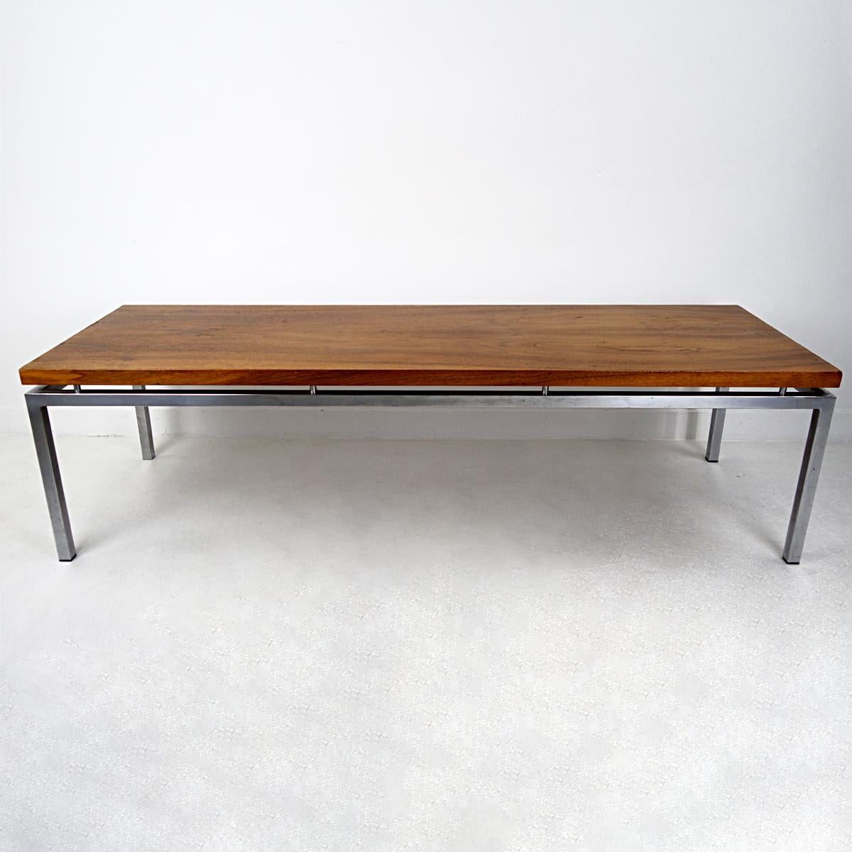 This long (150 cm / 59 inch) and sleek ( 50 cm / 19.7 inch) coffee table is very elegant and airy. This is not only caused by its dimensions but also because the teak wood top seems to float above the chrome frame as it is mounted by very smart