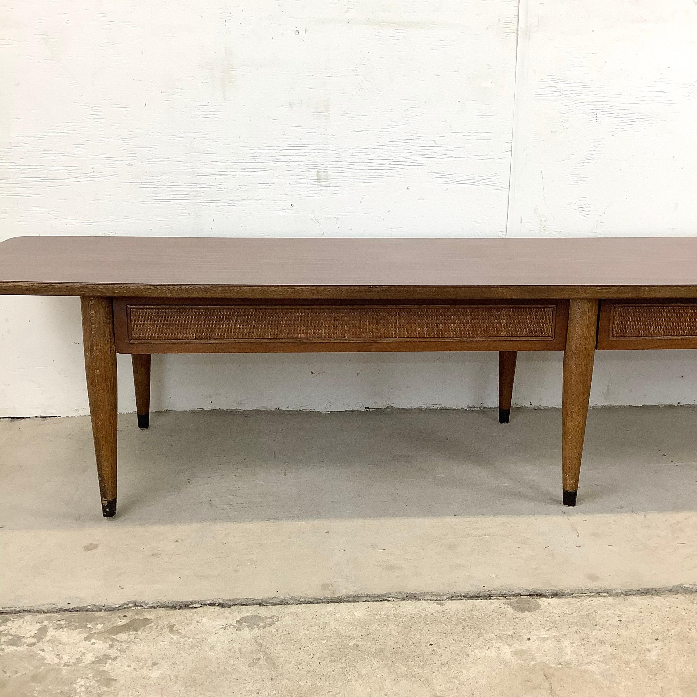This long and low midcentury coffee table from American of Martinsville features a furable faux wood laminate table top and Dual drawers for plenty of storage. Ideal for sofa seating area this six foot vintage modern coffee table makes a simple yet